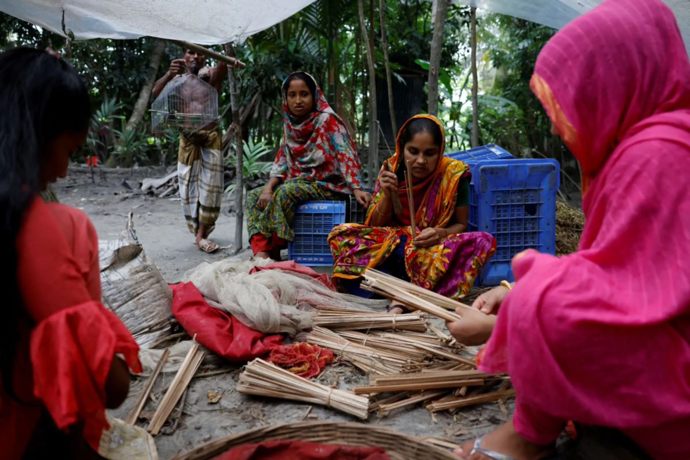 Bangladeshi women cut leaves into thin pieces at their home in Pirojpur, Bangladesh, August 18, 2022. REUTERS/Mohammad Ponir Hossain