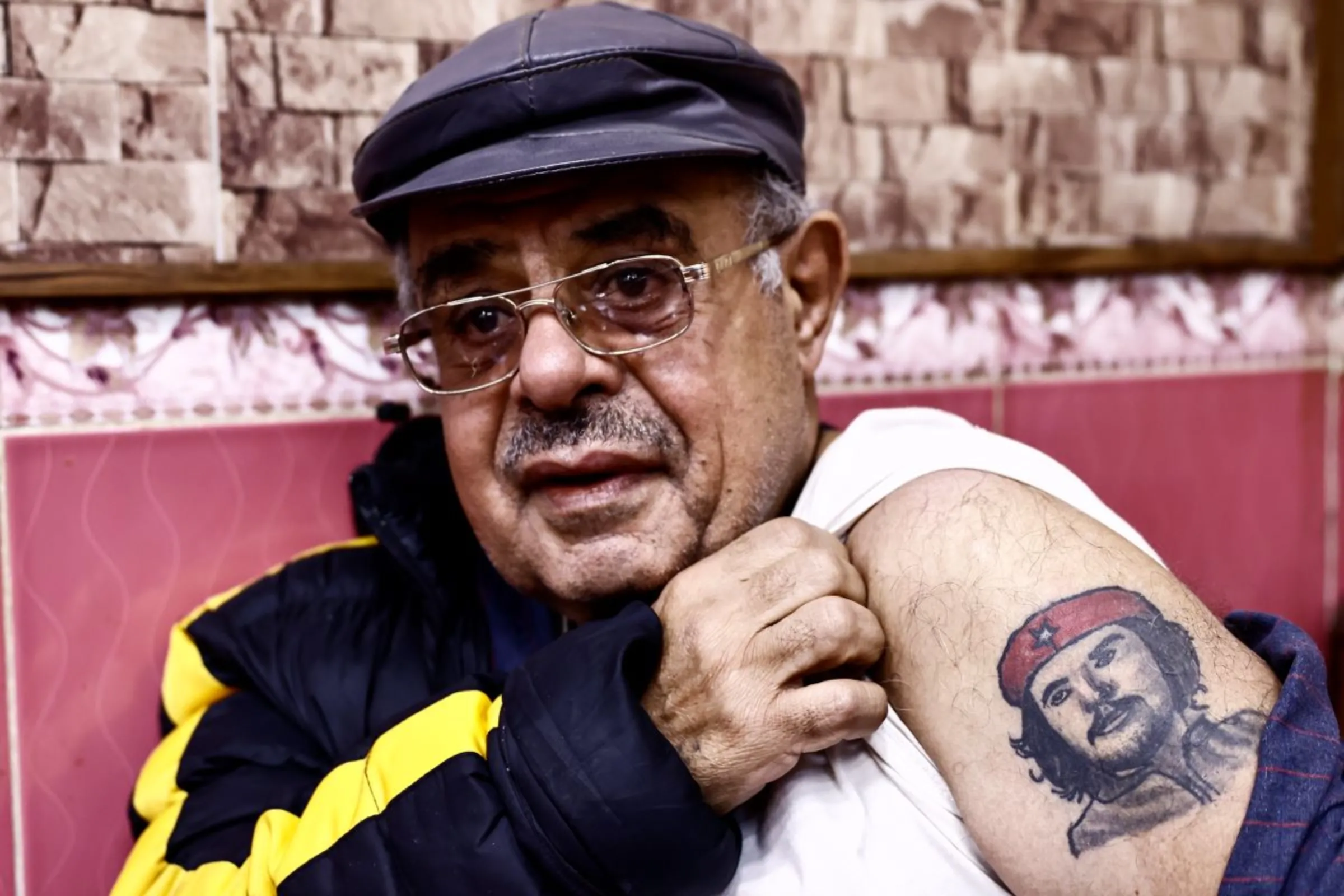 Najah Hadi shows off his Ernesto 'Che' Guevara while sitting  a café by Al-Mutanabi street, Baghdad, Iraq, February 3, 2023. Thomson Reuters Foundation/Abdullah Dhiaa al-Deen.