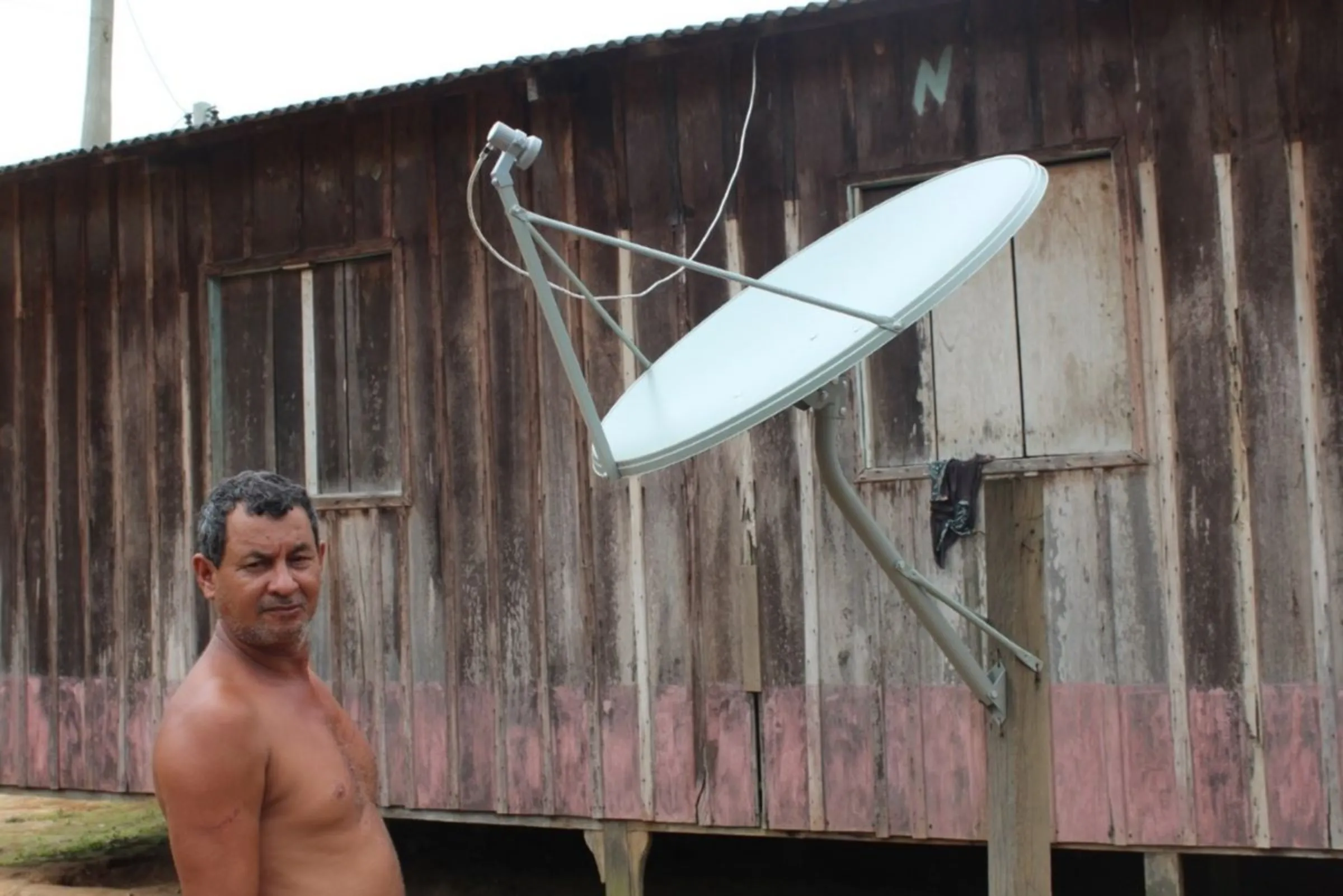 Amazon forest collector Cimião Alves shows a satellite antenna by his wooden house in the Pirapitinga community in Humaitá, Amazonas state, Brazil, Feb 26, 2024. THOMSON REUTERS FOUNDATION/André Cabette Fábio