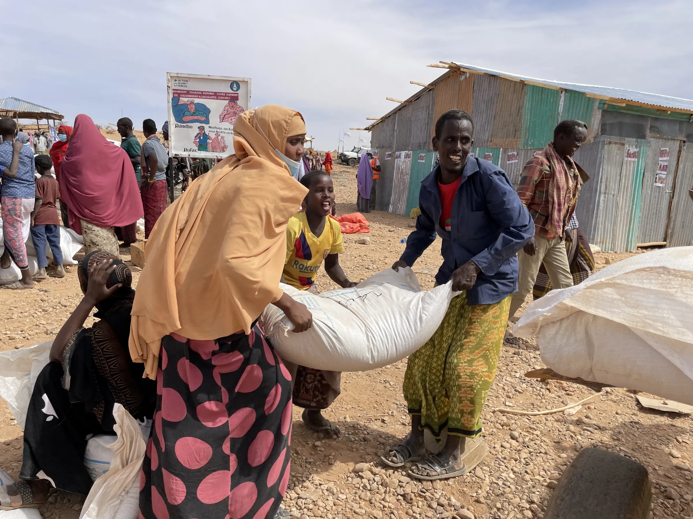 People carry bags of relief grains at a camp for the Internally Displaced People in Adadle district in the Somali region, Ethiopia, January 22, 2022. Claire Nevill/World Food Programme/Handout via REUTERS