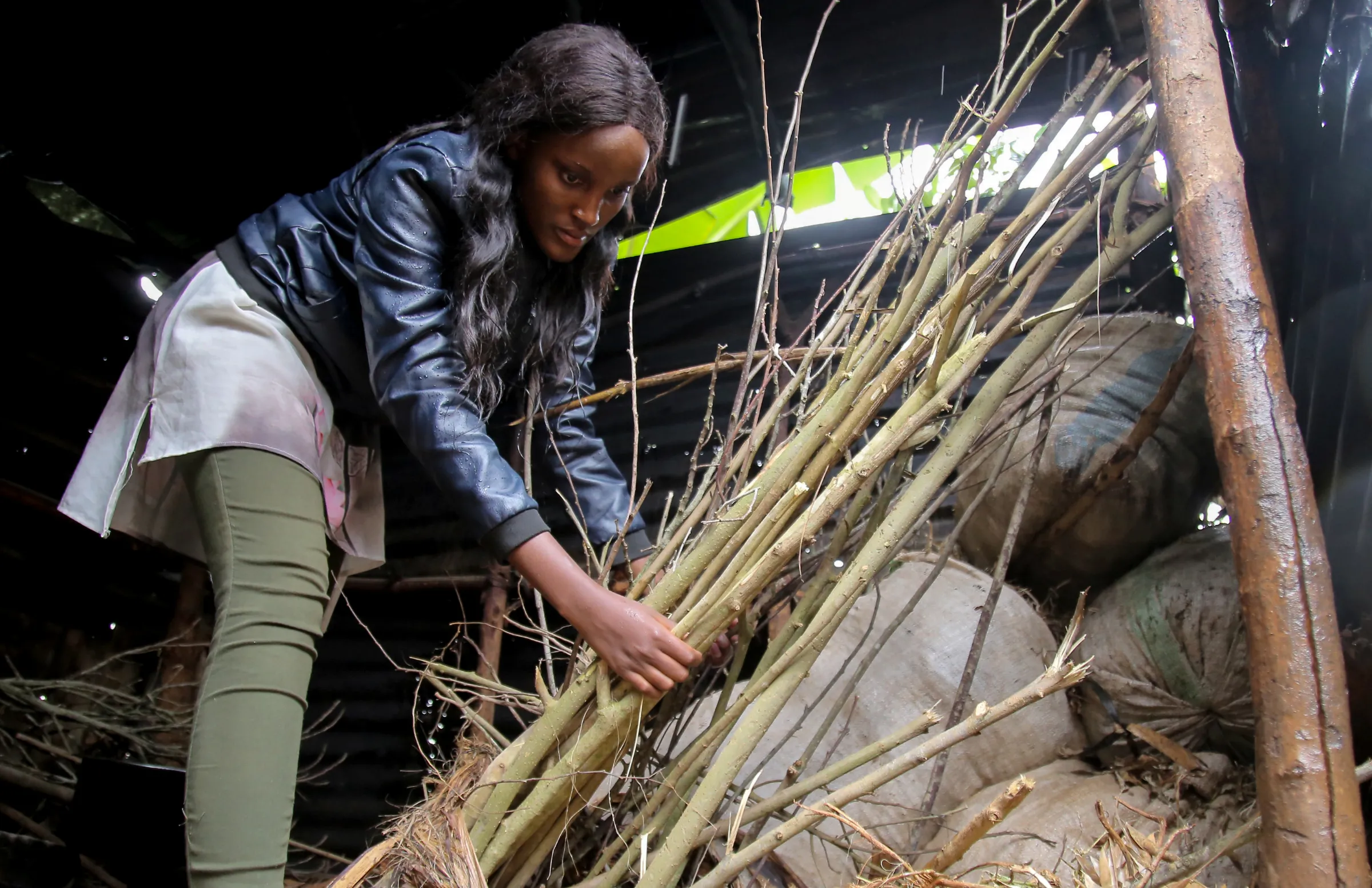 Ugandan climate change activist Vanessa Nakate, looks at the firewood cut from the forests as she visits the kitchen of Luwunga Primary school in Buwama, Mpigi district, Uganda, September 22, 2020. Picture taken September 22, 2020. REUTERS/Abubaker Lubowa