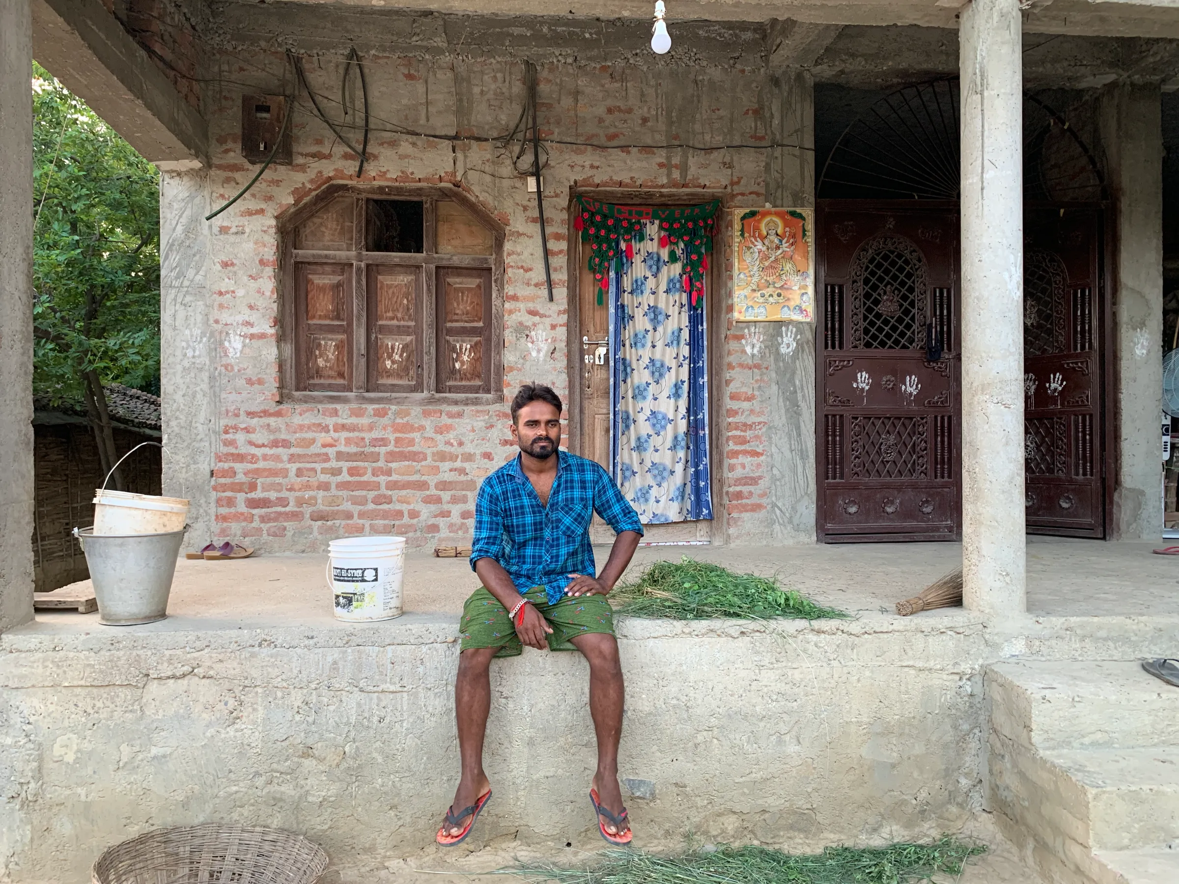 Santosh Kumar Yadav poses for a picture outside his newly built home in Barmajhiya, Nepal, August 25, 2022. Thomson Reuters Foundation/Pramod Acharya