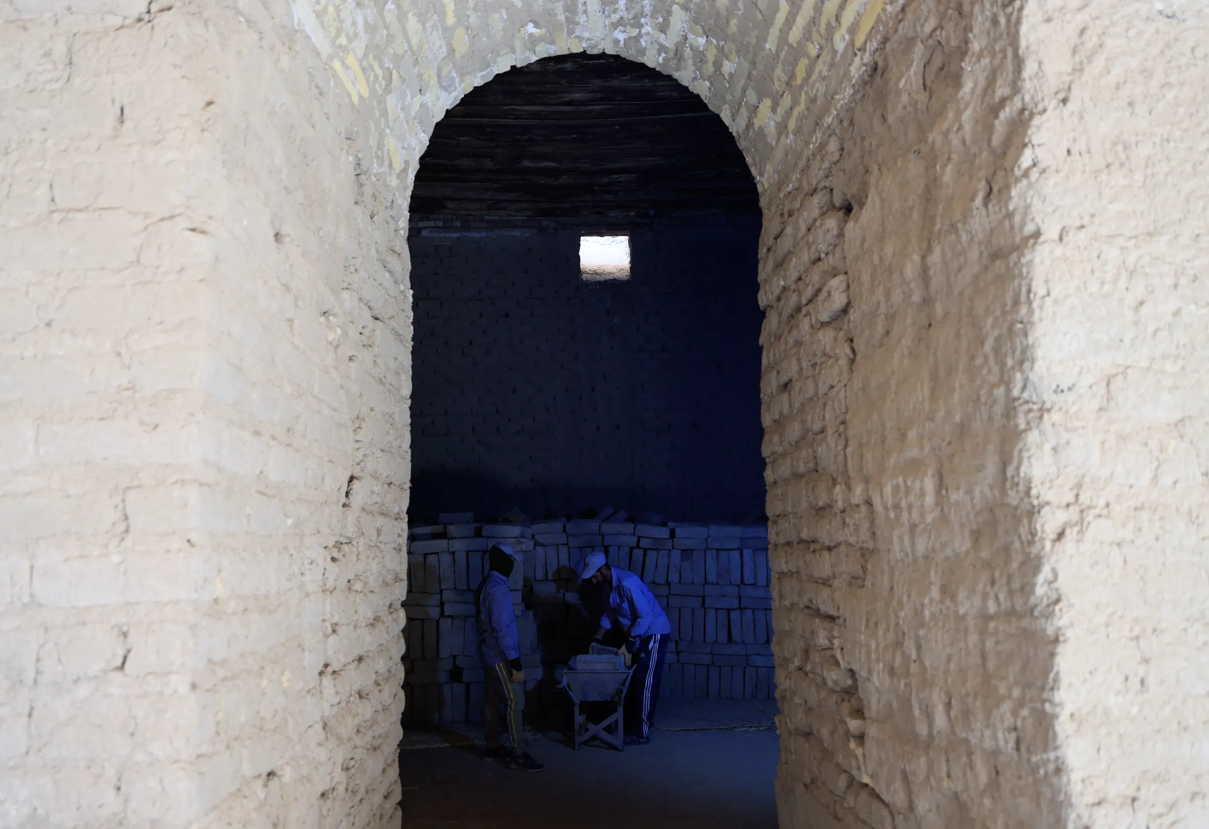 Two workers from World Monument Fund set out sun-crude bricks inside Ninmah Temple in Babylon, Iraq, October 13, 2022