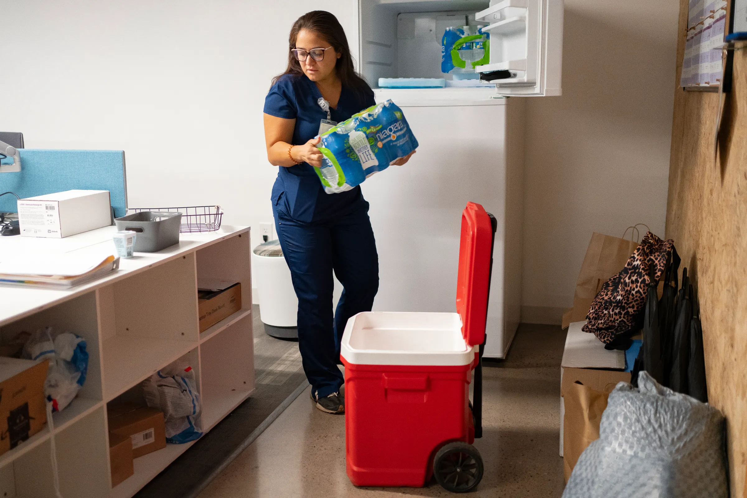 Nurse practitioner Perla Puebla of Circle the City packs water bottles for people in need on the streets of Phoenix, Arizona. July 15, 2024. Thomson Reuters Foundation/Rebecca Noble