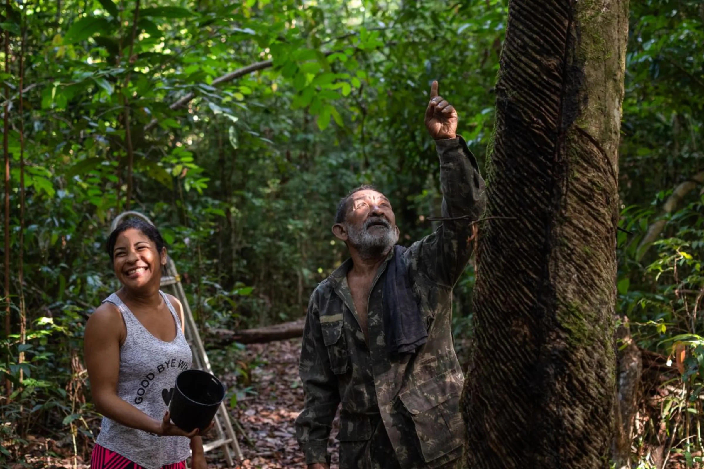 Corina Magno and her father Manoel Magno are pictured in the jungle where he has planted dozens of rubber trees in Pará, Brazil, January 17, 2023. Thomson Reuters Foundation/Cícero Pedrosa Neto