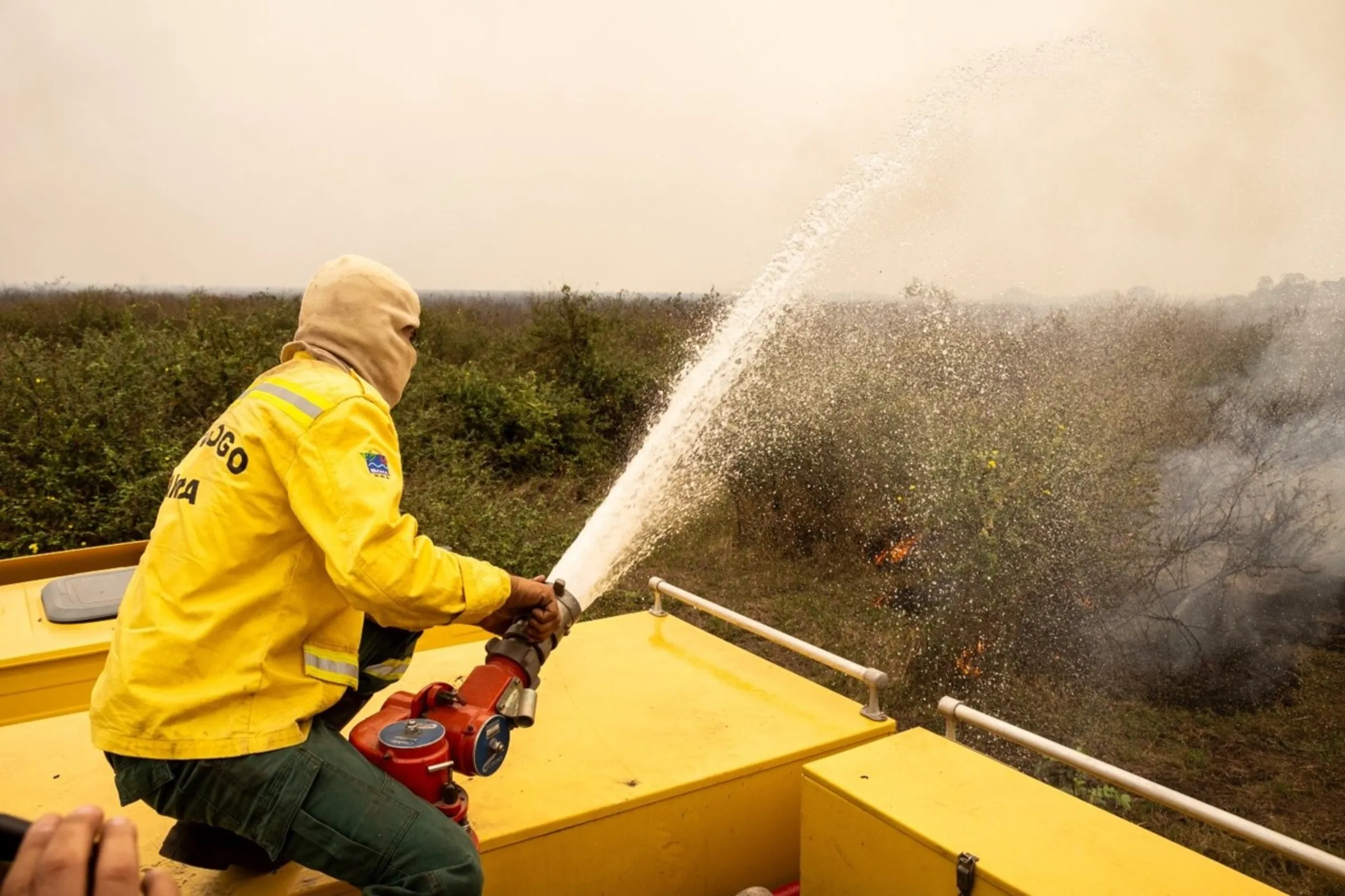 A firefighter from the Prevfogo brigade hoses down wildfires at the Pantanal wetland, Corumbá, Brazil, September, 11, 2024. Thomson Reuters Foundation/Henrique Kawaminami