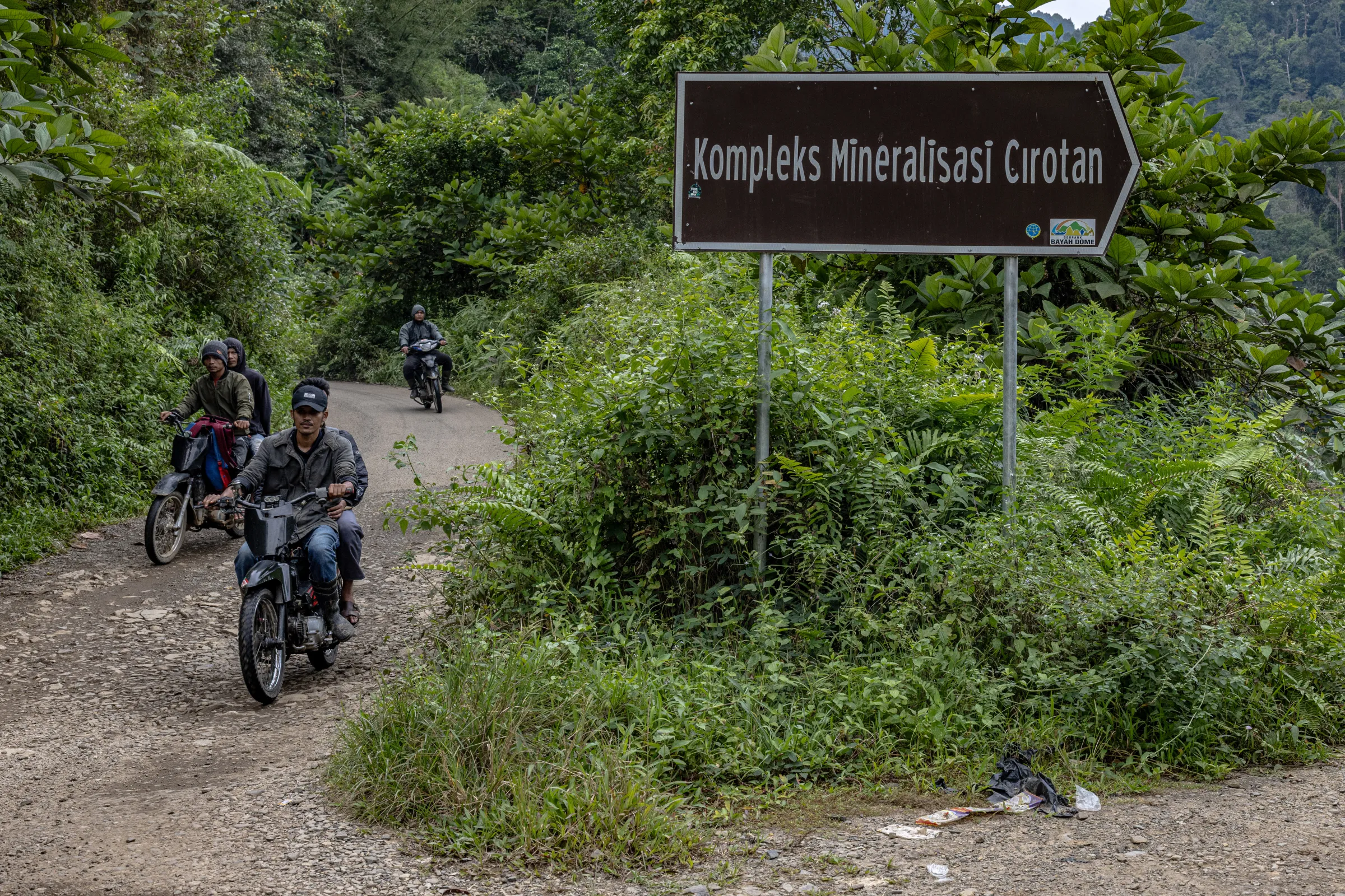 Residents pass by a road sign that reads 'Kompleks Mineral Cirotan' in Citorek Kidul, Banten, Indonesia, July 14, 2025. Thomson Reuters Foundation/Yudha Baskoro