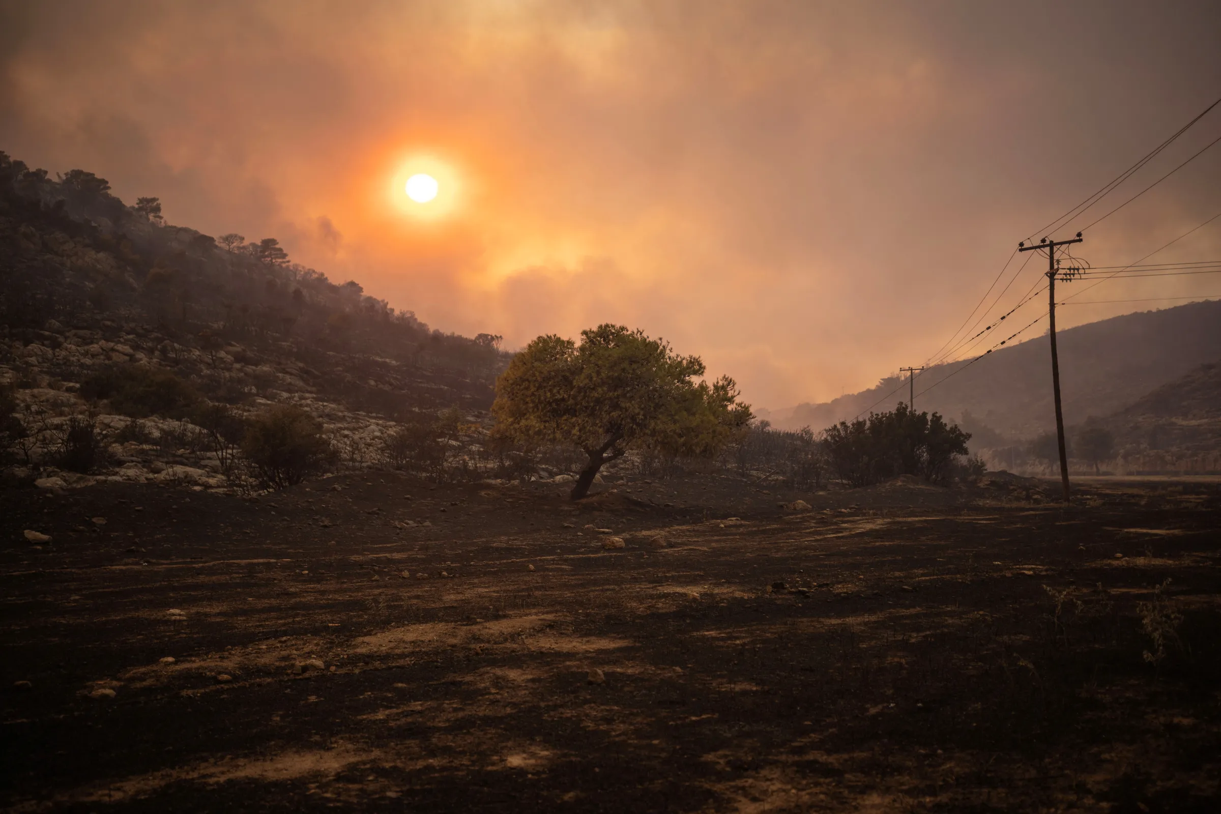 The sun sets as a wildfire burns in the village of Hasia, near Athens, Greece August 22, 2023