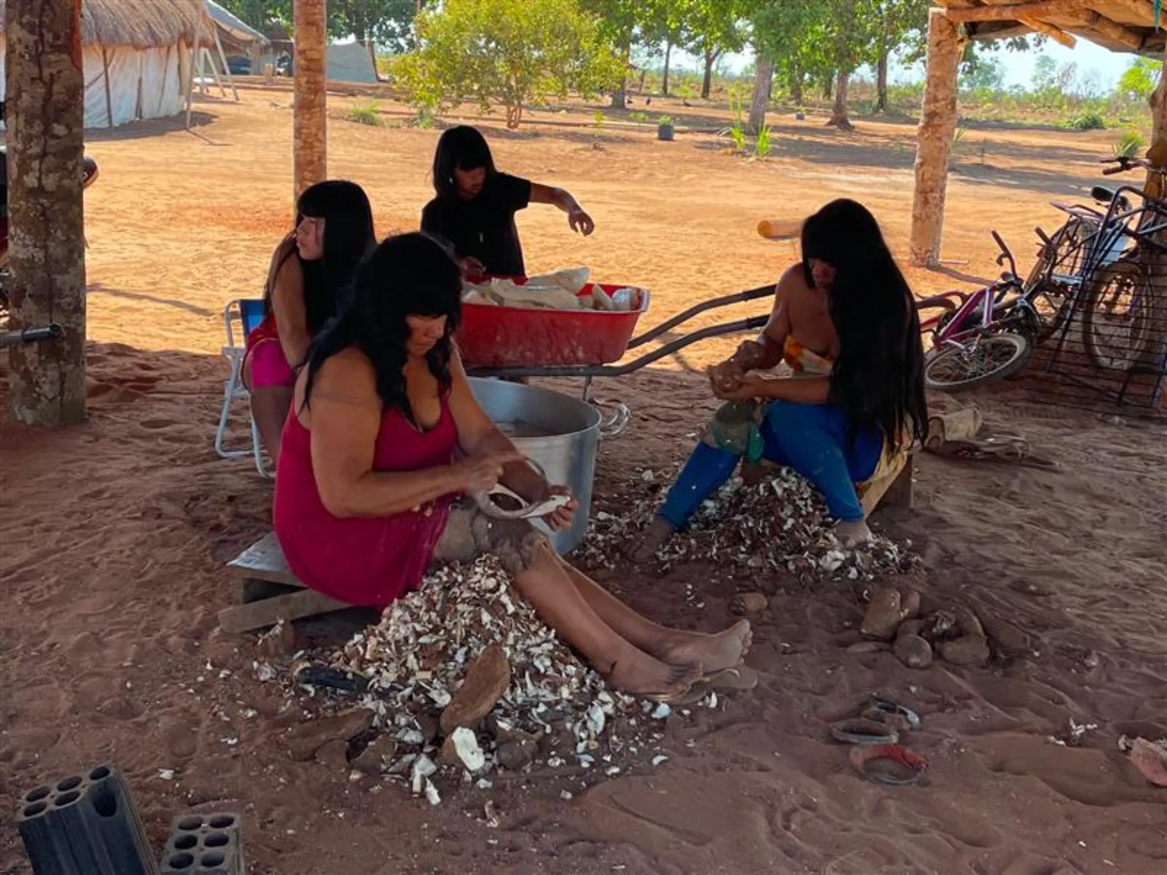 A group of women peeling manioc roots, a staple food in the Kalapalo people’s Tanguro village, Xingu Indigenous Park, Brazil, September 4, 2025. THOMSON REUTERS FOUNDATION/André Cabette Fábio