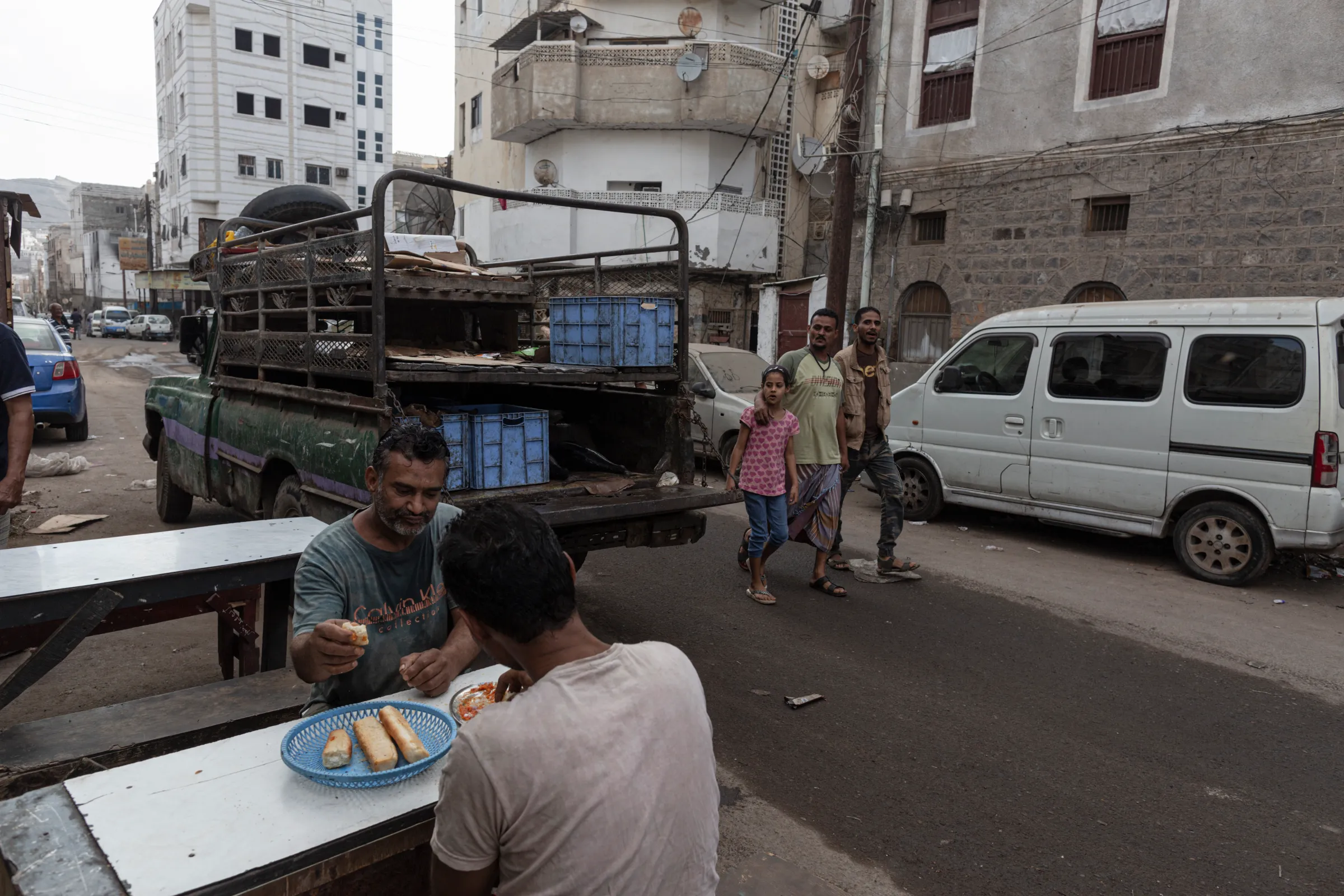 Men eat bread for breakfast at a cafe in Aden, Yemen, on February 26, 2022. Thomson Reuters Foundation/Sam Tarling