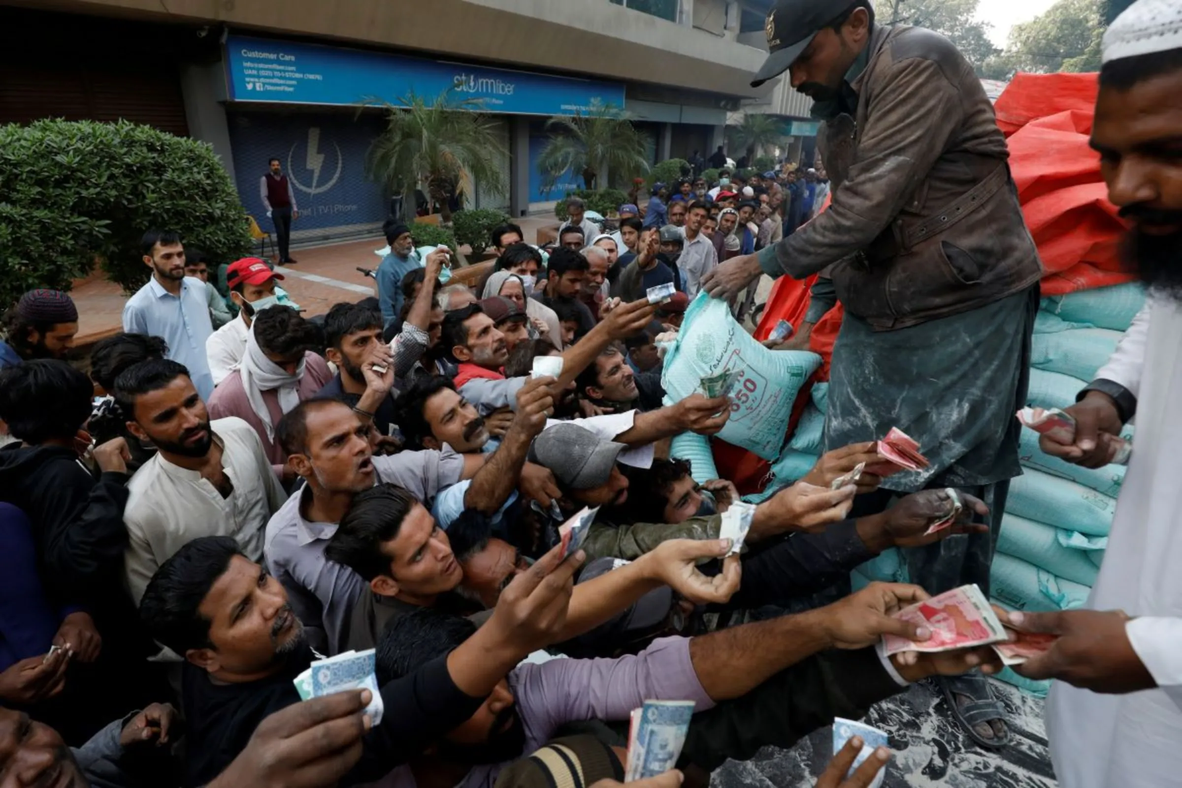 Men reach out to buy subsidised flour sacks from a truck in Karachi, Pakistan January 10, 2023. REUTERS/Akhtar Soomro