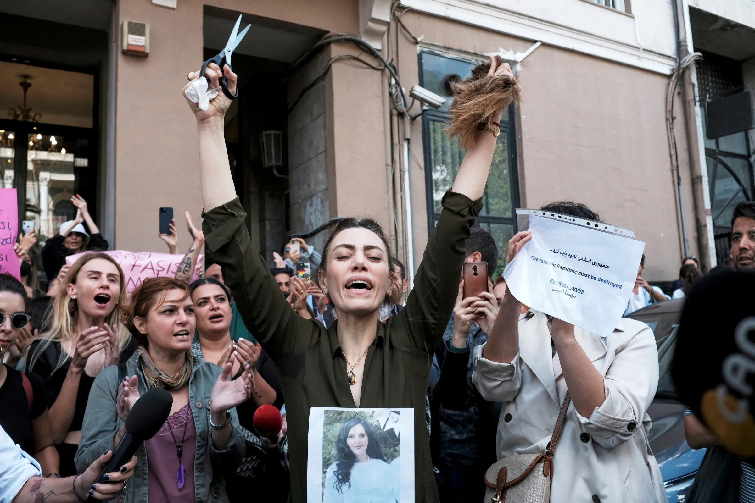 Nasibe Samsaei, an Iranian woman living in Turkey, reacts after she cut her hair during a protest following the death of Mahsa Amini, outside the Iranian consulate in Istanbul, Turkey, September 21