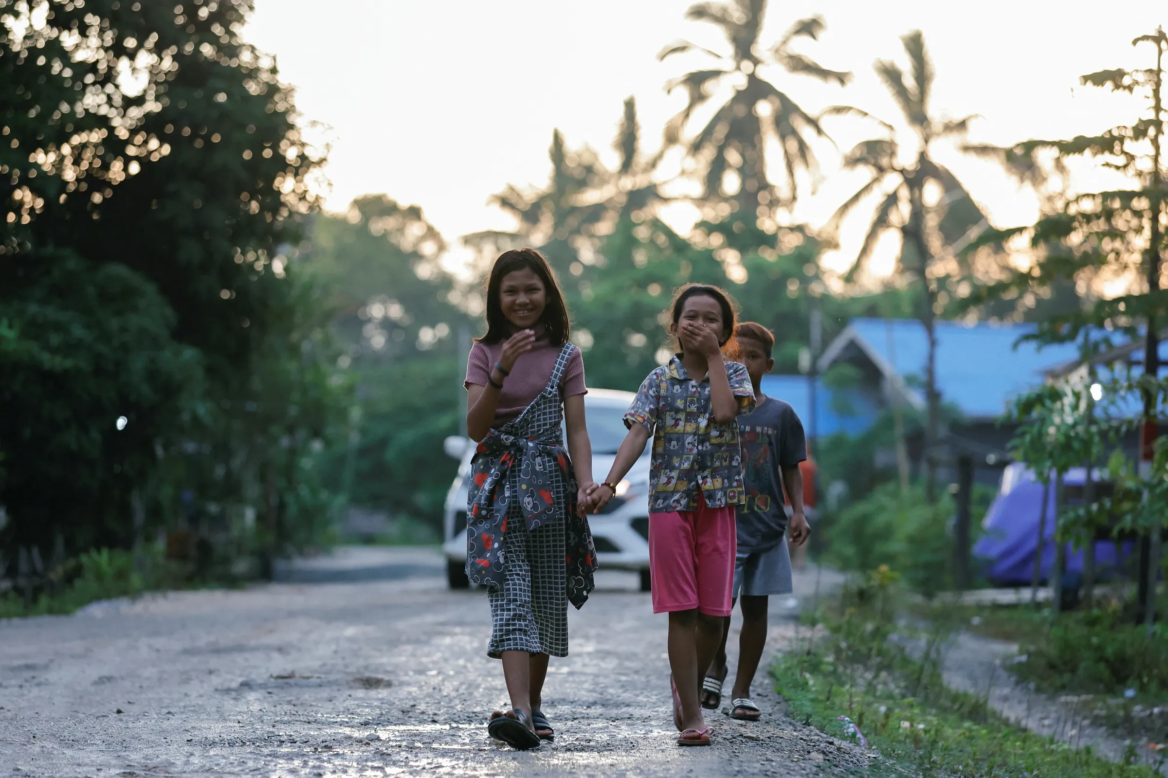 Indigenous Balik tribe's children react to camera as they walk along a road at their village, located near the Indonesia's projected new capital known as Nusantara National Capital, in Sepaku, East Kalimantan province, Indonesia, March 6, 2023. REUTERS/Willy Kurniawan
