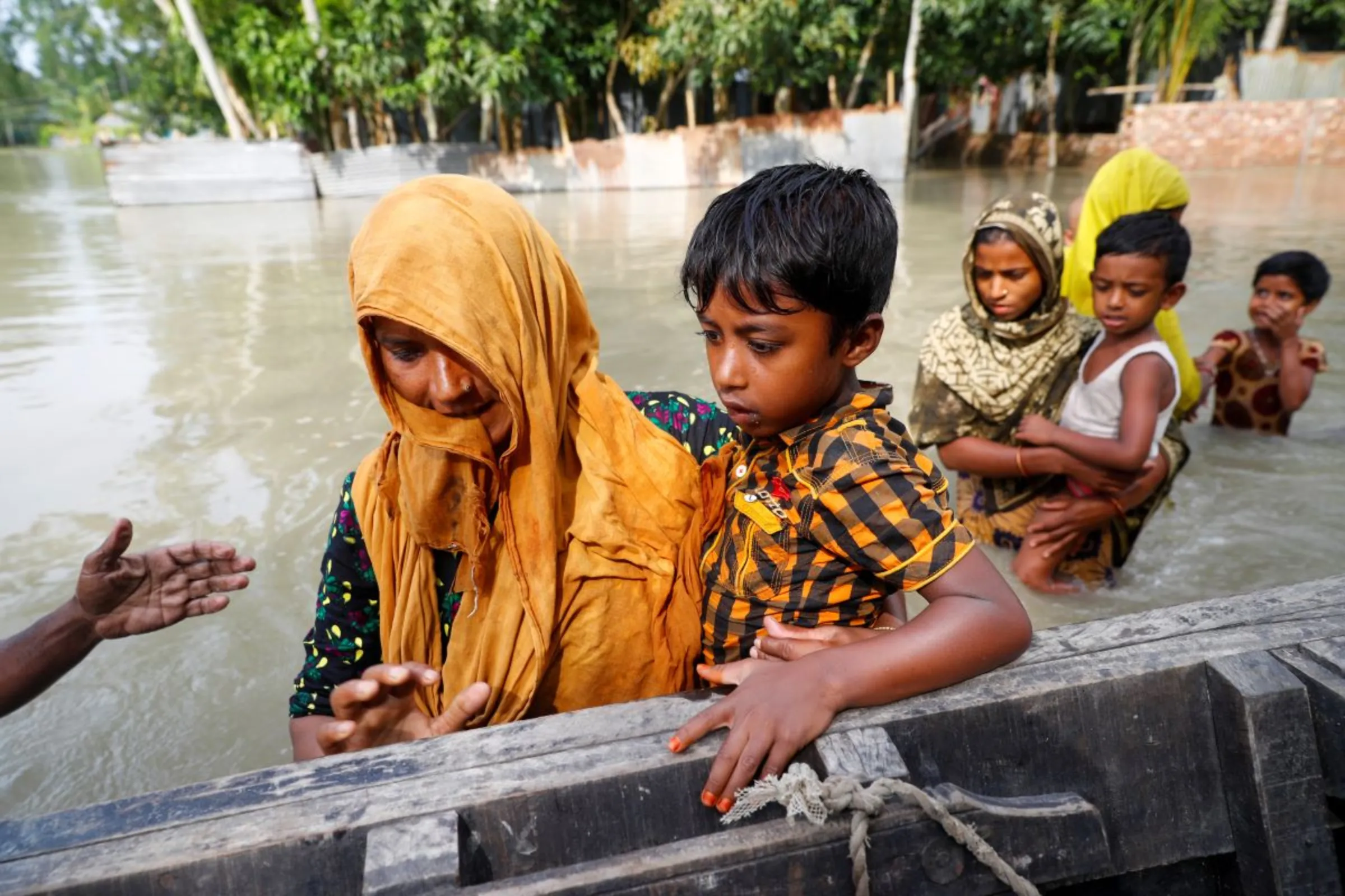 Flood-affected people get on a boat to cross a stream in Jamalpur, Bangladesh, July 18, 2020. REUTERS/Mohammad Ponir Hossain