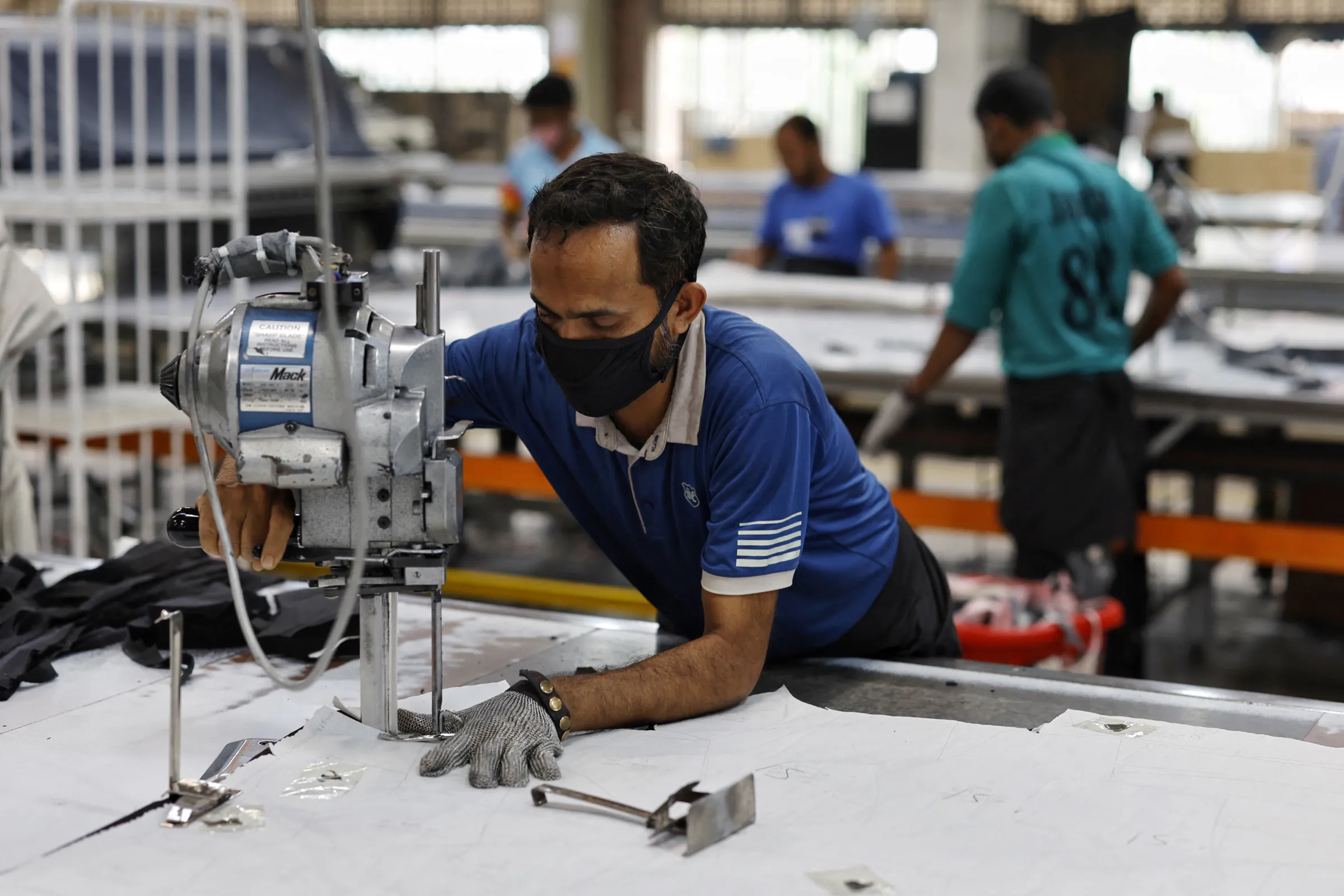 A Bangladeshi male garment worker uses cutting machine in the cutting section of a factory in Gazipur, Bangladesh, April 9, 2025. REUTERS/Mohammad Ponir Hossain