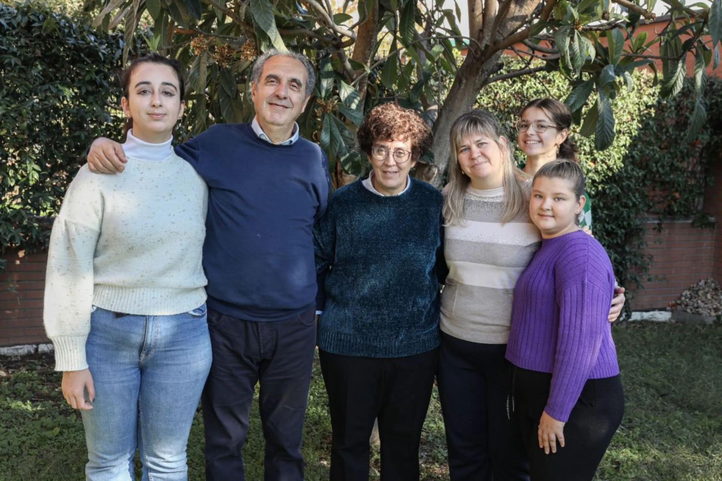 Natalia Stetsyna poses with her family, and her hosts in Milan, Italy, 2023