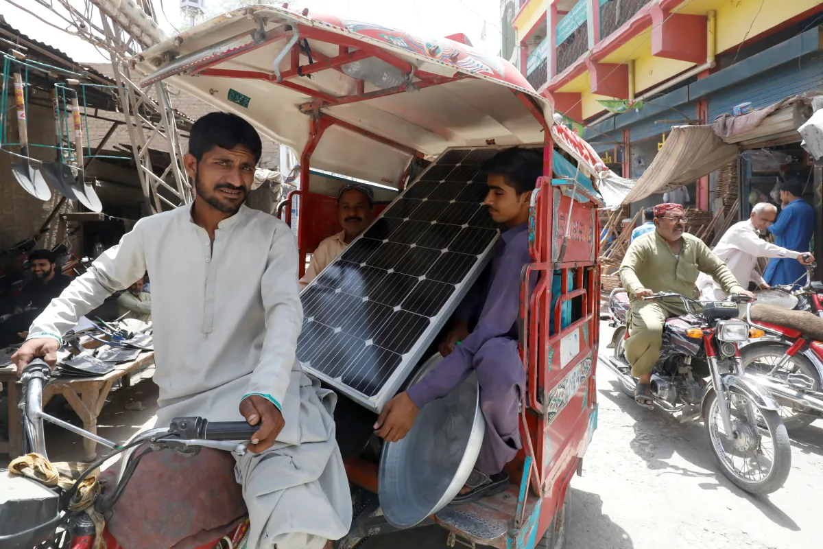 People in a rickshaw carry a solar panel, during a heatwave, in Jacobabad, Pakistan, May 14, 2022. REUTERS/Akhtar Soomro