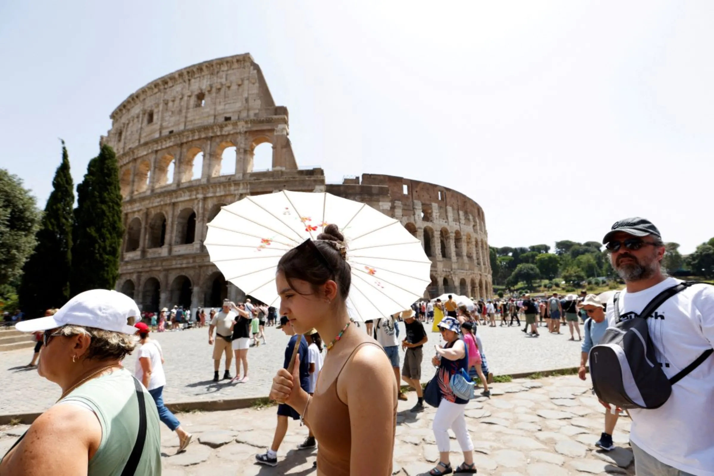 People walk near the Colosseum during a heat wave across Italy as temperatures are expected to rise further in the coming days, in Rome, Italy July 17, 2023