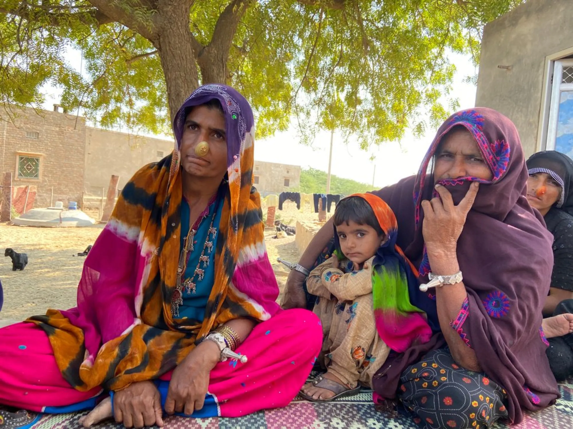 Dadda Khatoon (left) poses for a picture with other women and children of her village near Bhadla Solar Park, Rajasthan, India, December 11, 2021