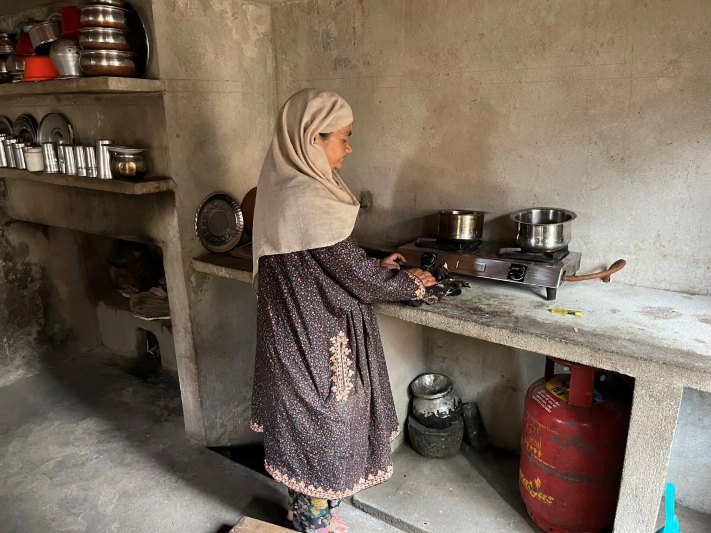 Khadjia Begam, whose husband died in a recent lightning strike, prepares food in Budgam, India, May 29, 2022