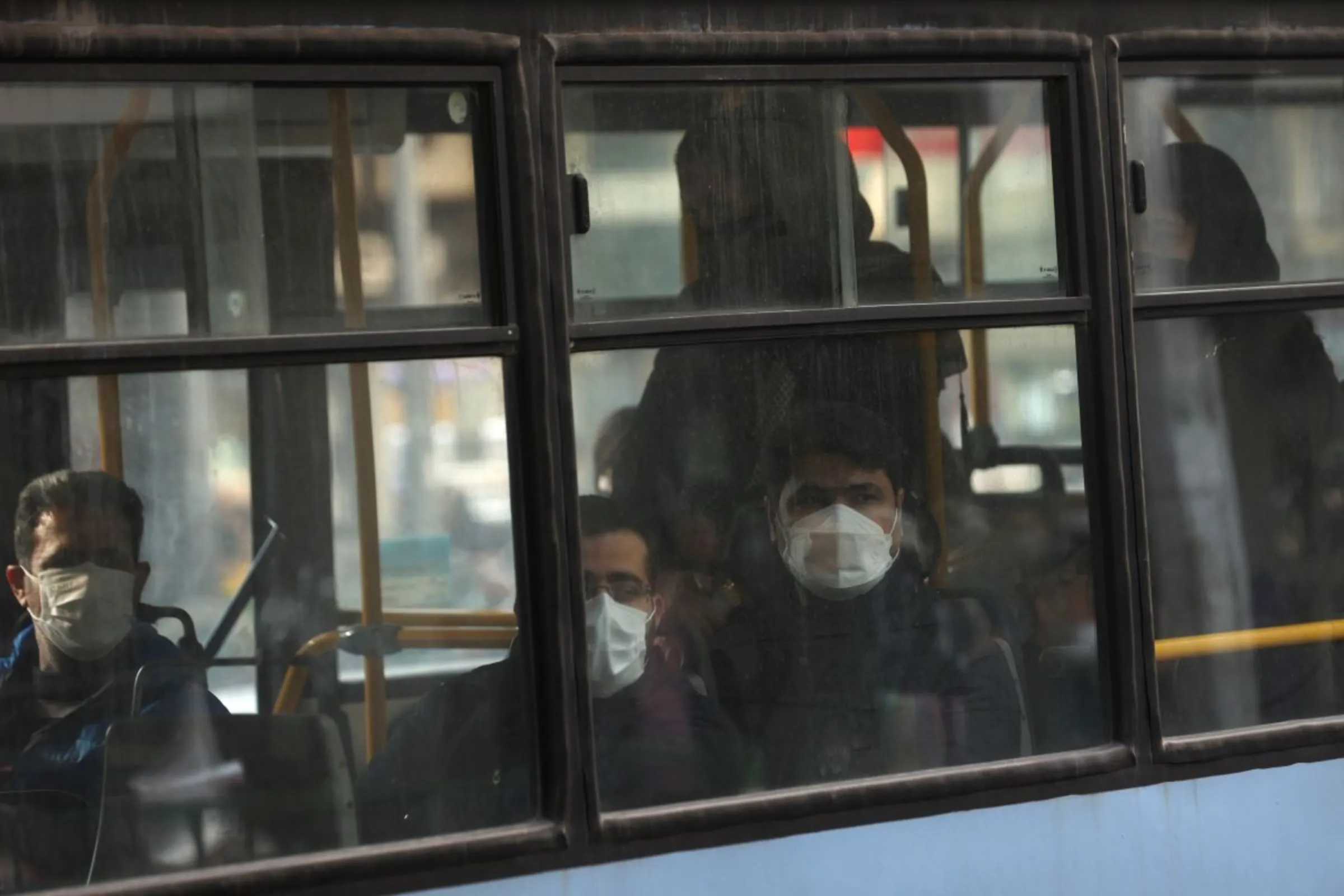 An Iranian man wears a protective mask as he sits in a bus following the increase in air pollution in Tehran, Iran, November 24, 2021. Majid Asgaripour/WANA (West Asia News Agency) via REUTERS
