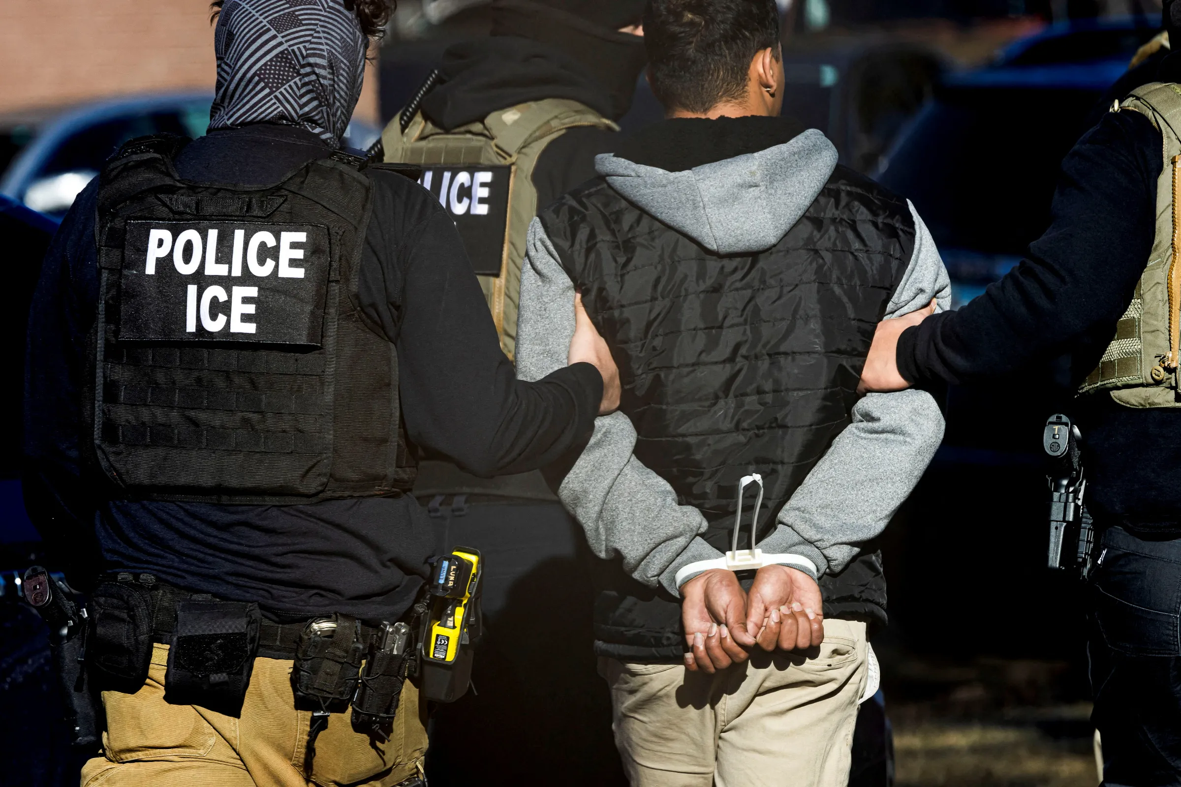 Immigration and Customs Enforcement agents detain a man after conducting a raid at the Cedar Run apartment complex in Denver, Colorado, U.S., February 5, 2025. REUTERS/Kevin Mohatt