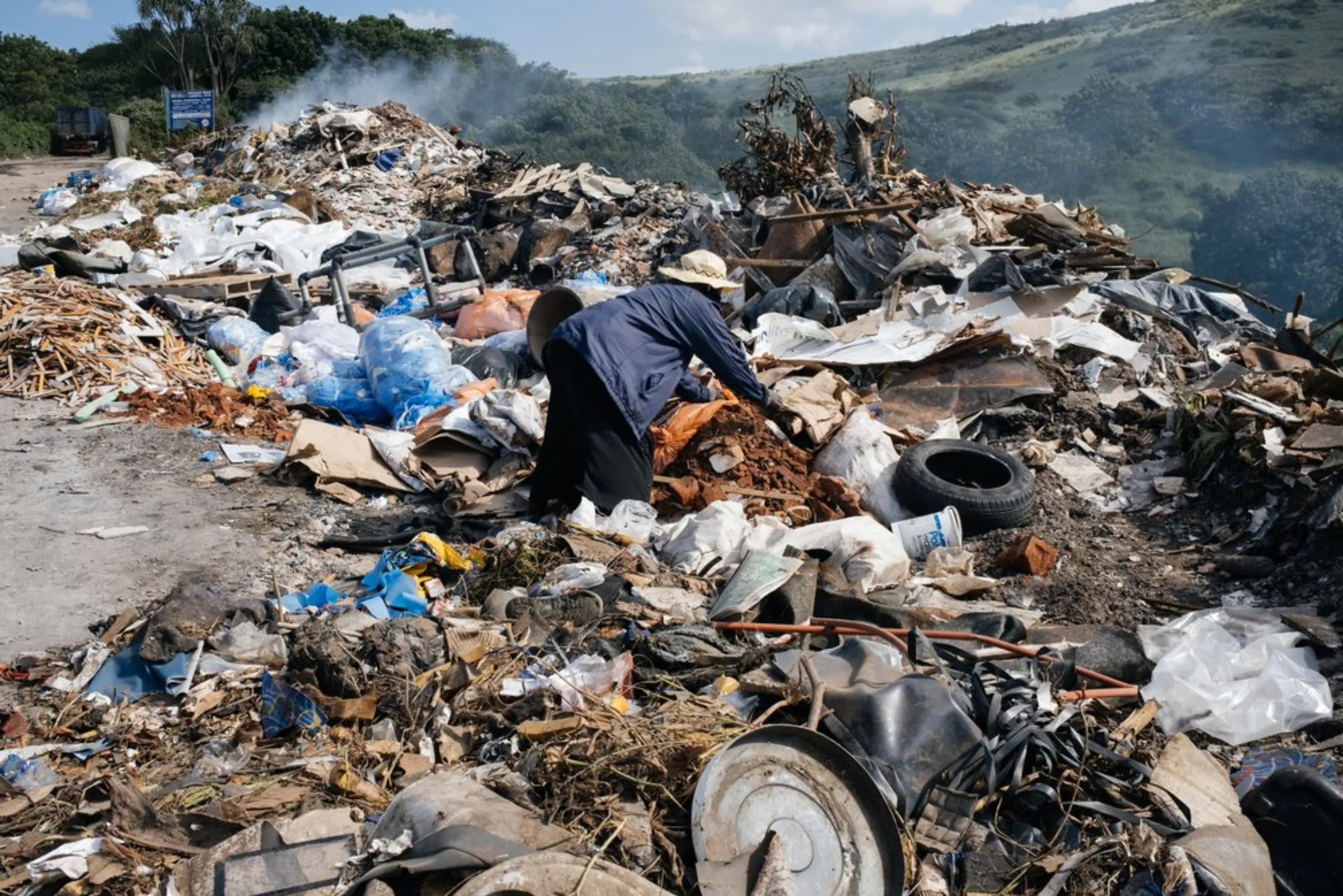 A woman picks through waste at the Bisasar Road landfill site in Durban, South Africa, March 30, 2021