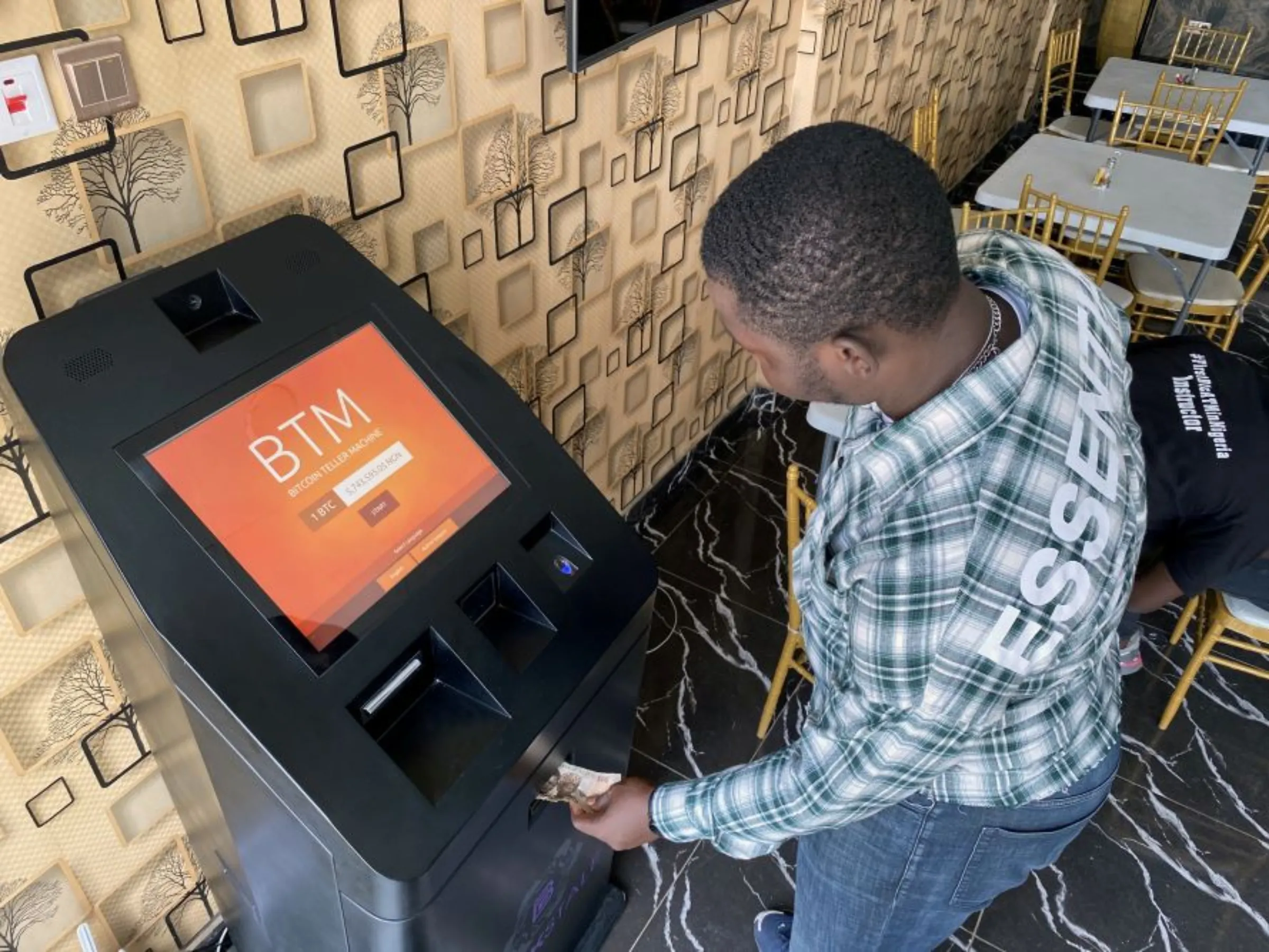 A bitcoin user buys bitcoins with naira on Bitcoin Teller Machine in Lagos, Nigeria September 1, 2020