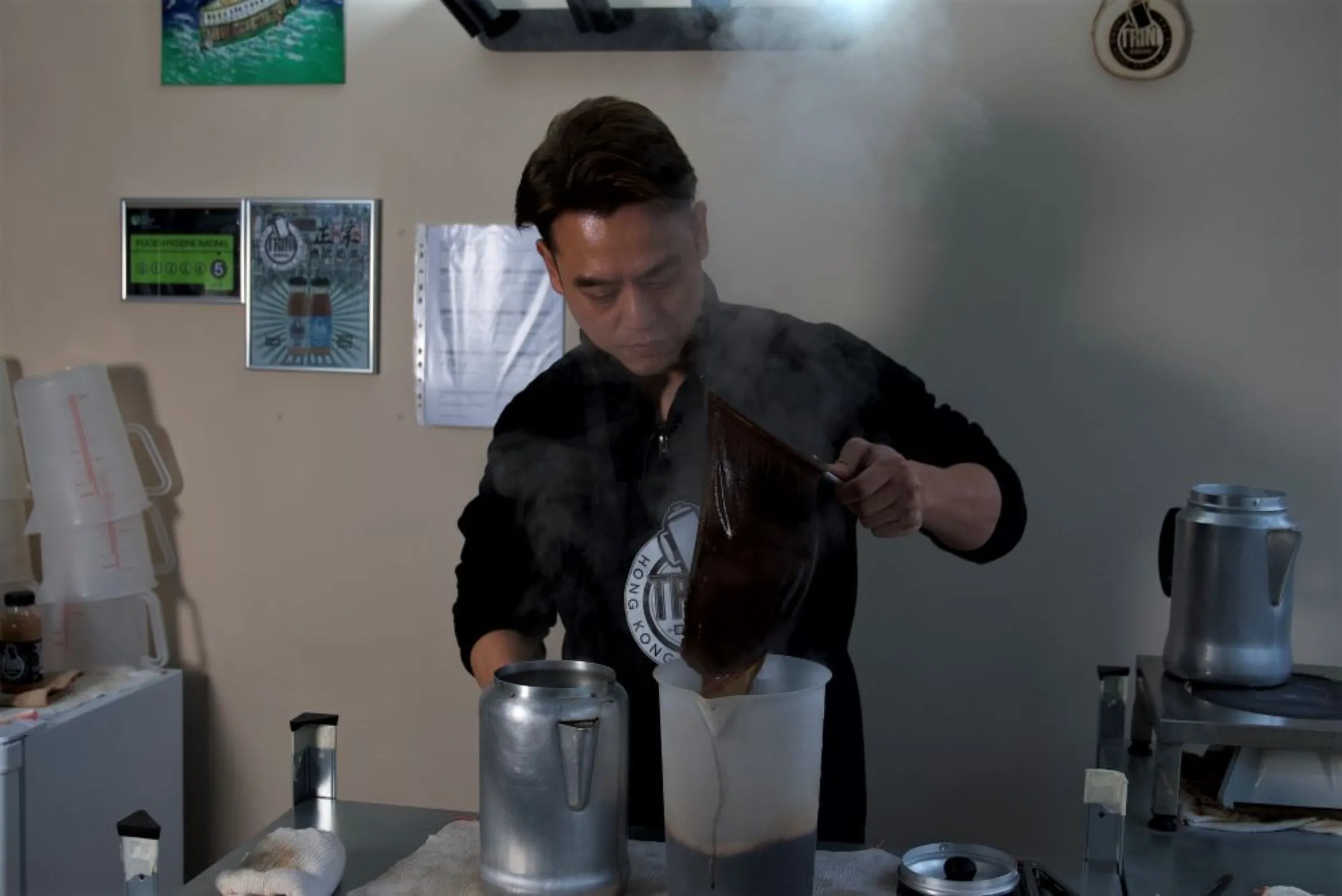 Eric Wong, founder of Trini Hong Kong Milk Tea, works in his kitchen in Sutton, South London, January 2023. Thomson Reuters Foundation