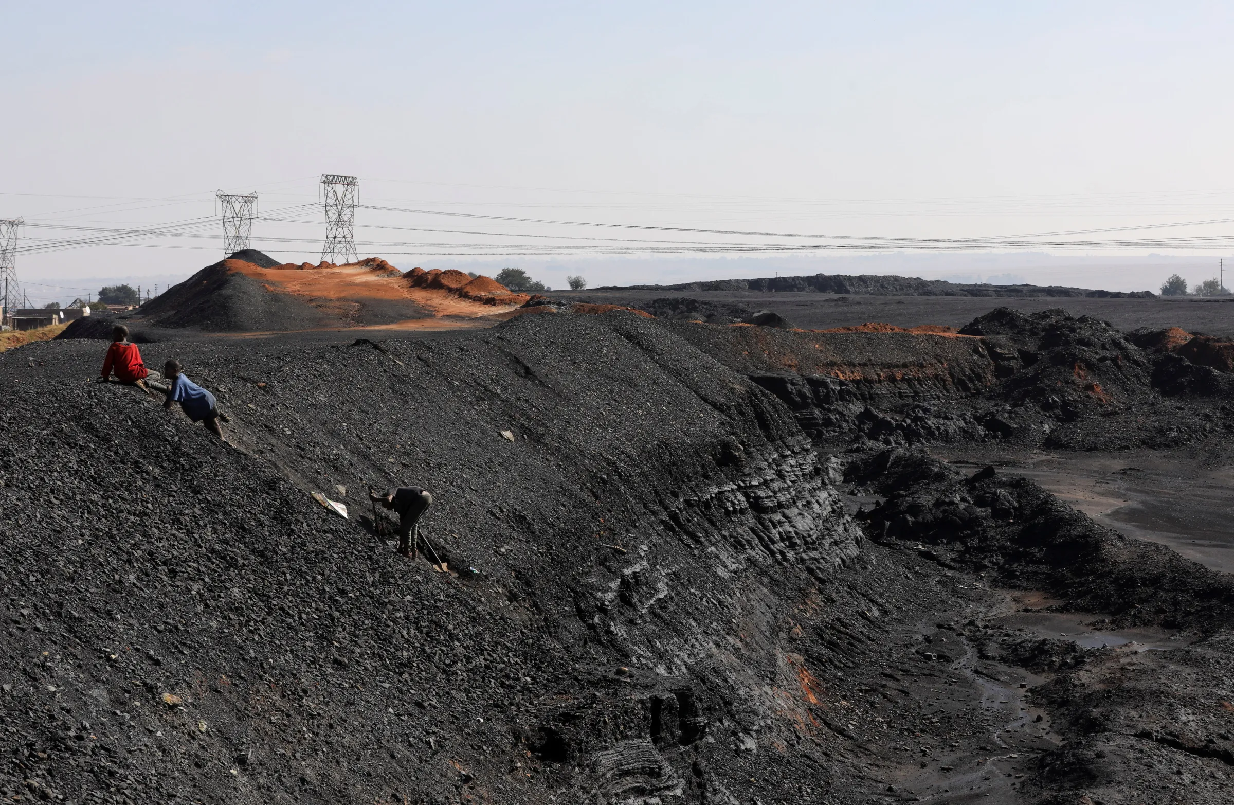 Children are seen collecting chunks of coal at a colliery in Emalahleni, in Mpumalanga province, South Africa, June 2, 2021. REUTERS/Siphiwe Sibeko