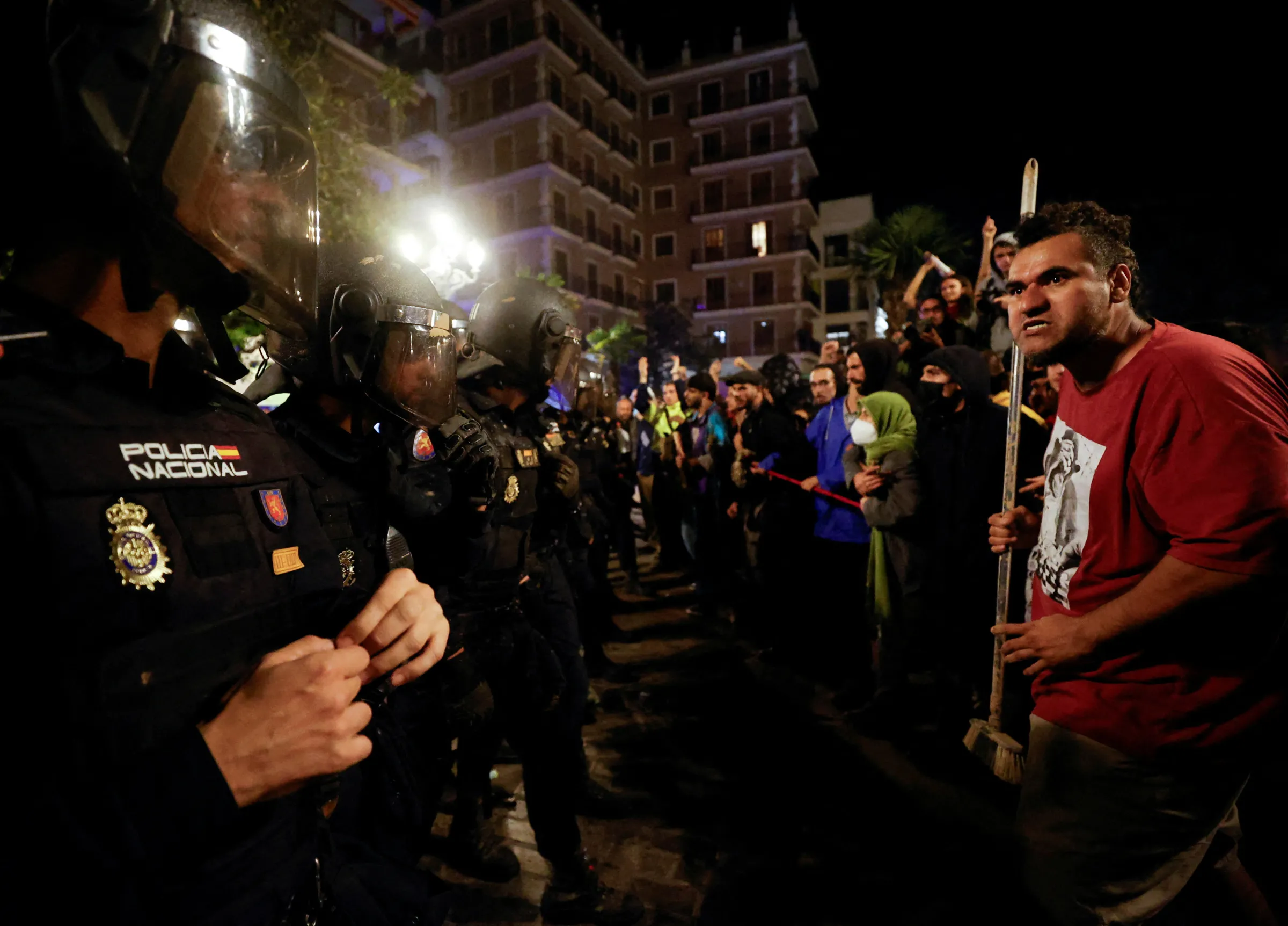 Demonstrators react in front of police officers in riot gear during a protest against Valencia's regional leader Carlos Mazon and the management of the emergency response to the deadly floods in eastern Spain, in Valencia, Spain, November 9, 2024. REUTERS/Eva Manez