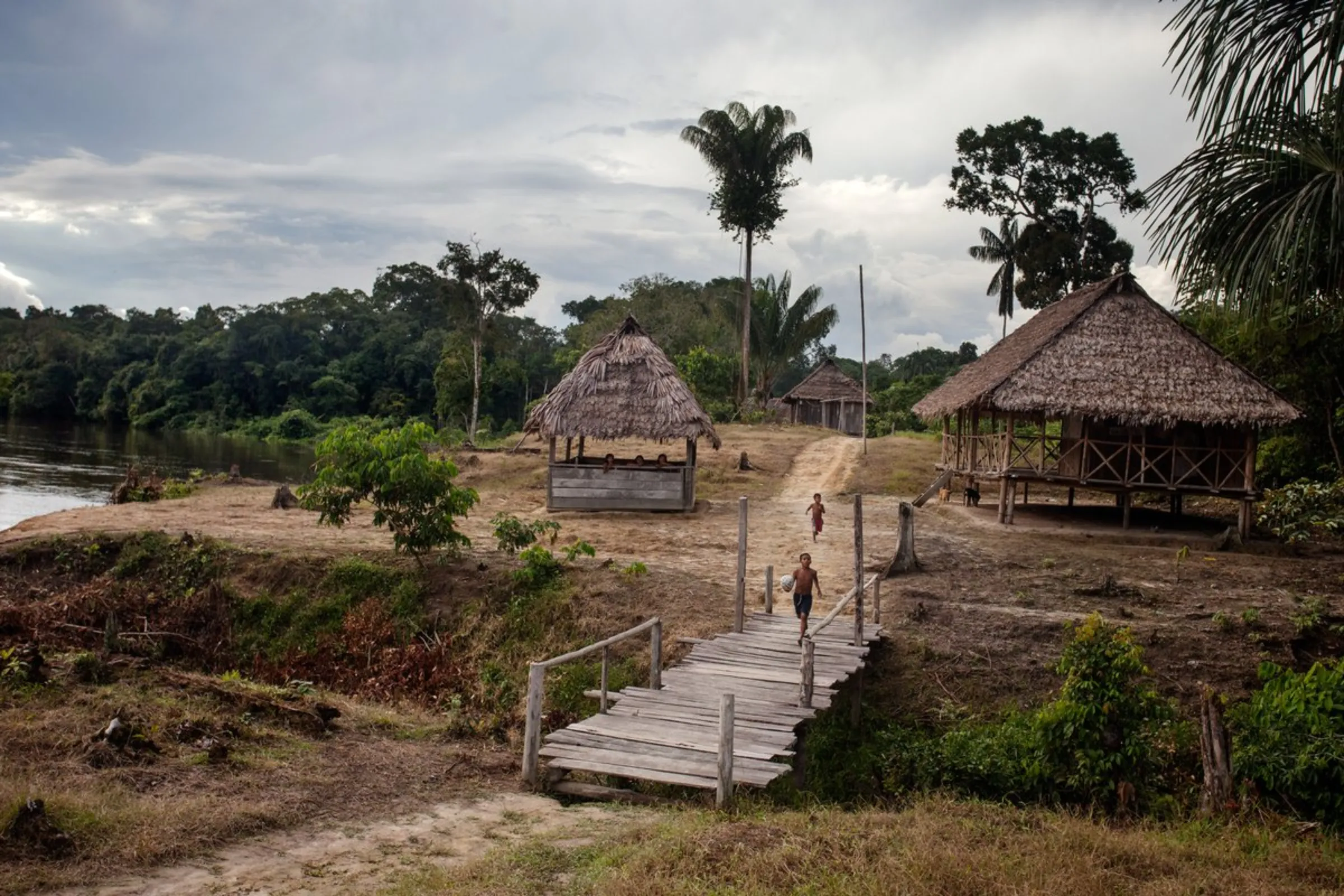 Indigenous children play at the Puerto Libre riverside community near thatched classrooms where native languages and cultural practices are taught, December 19, 2021