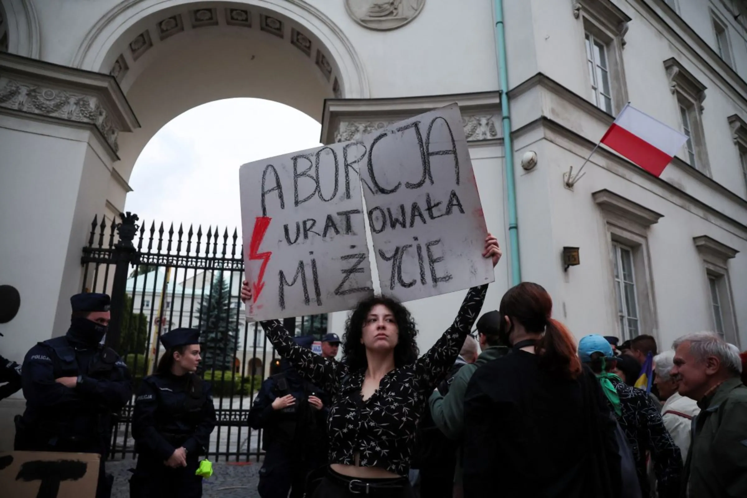 A person holds a sign that reads: 'Abortion saved my life' in front of the Ministry of Health building during a protest, after a pregnant woman died in hospital in an incident campaigners say is the fault of Poland's laws on abortion, which are some of the most restrictive in Europe, in Warsaw, Poland June 14, 2023. REUTERS/Kacper Pempel