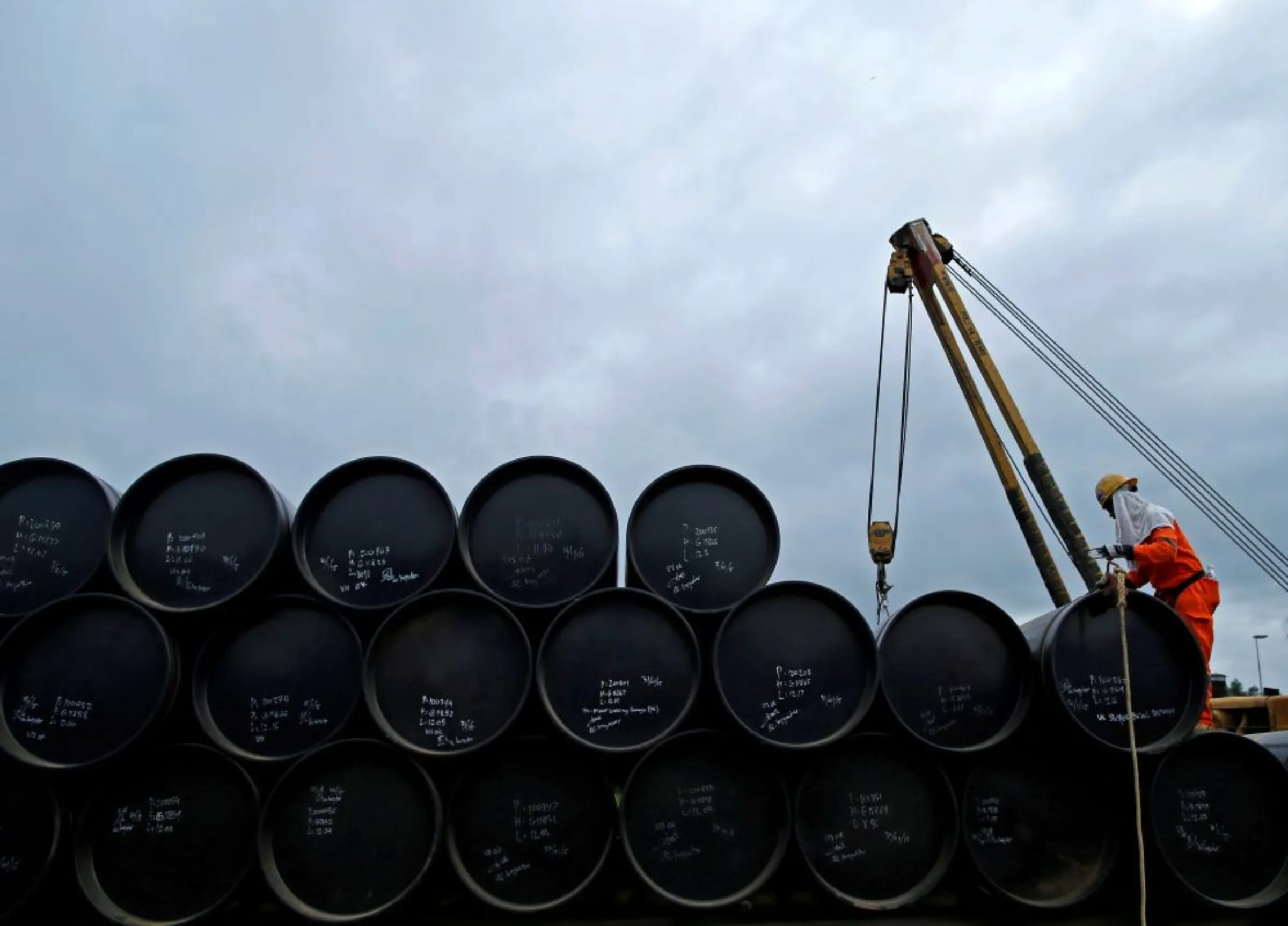 A worker prepares to transport oil pipelines to be laid for the Pengerang Gas Pipeline Project at an area 40km (24 miles) away from the Pengerang Integrated Petroleum Complex in Pengerang, Johor, February 4, 2015