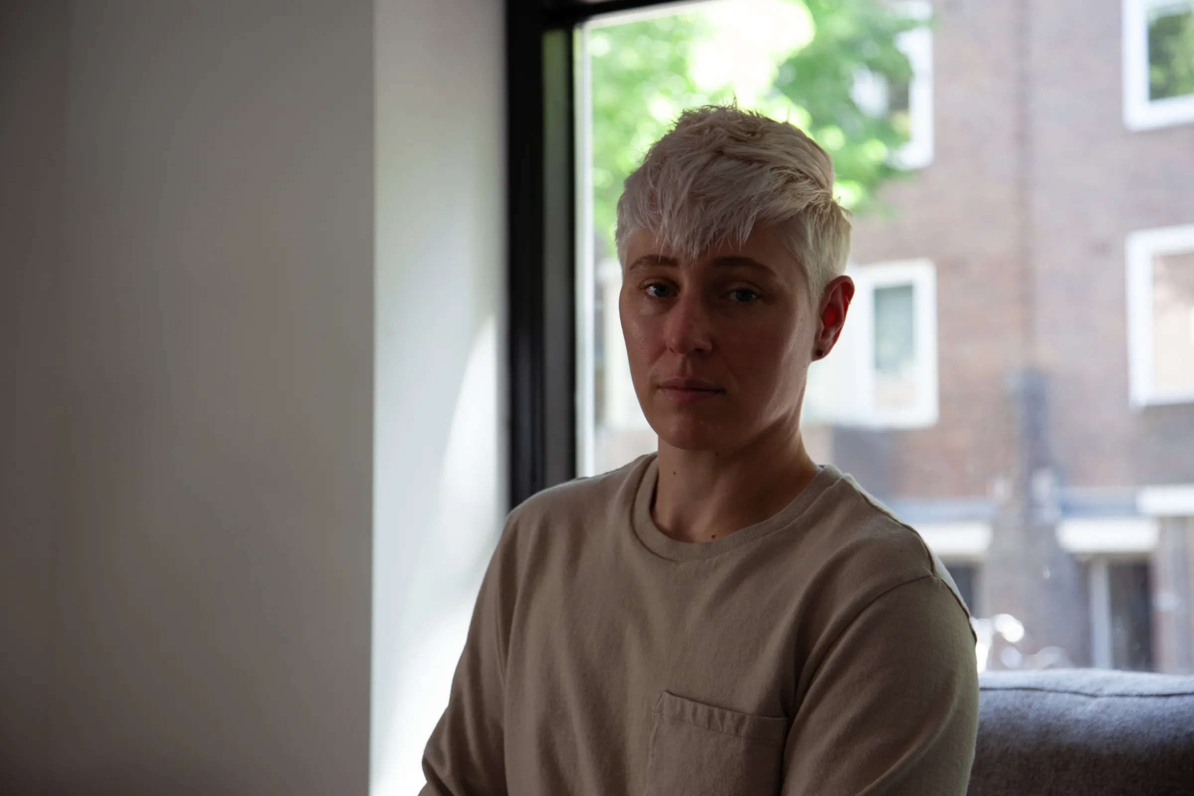 Jack Mercury sits by the window of the apartment he shares with his partner and two cats in Amsterdam West, 9 July 2025. /Ingrid Gercama