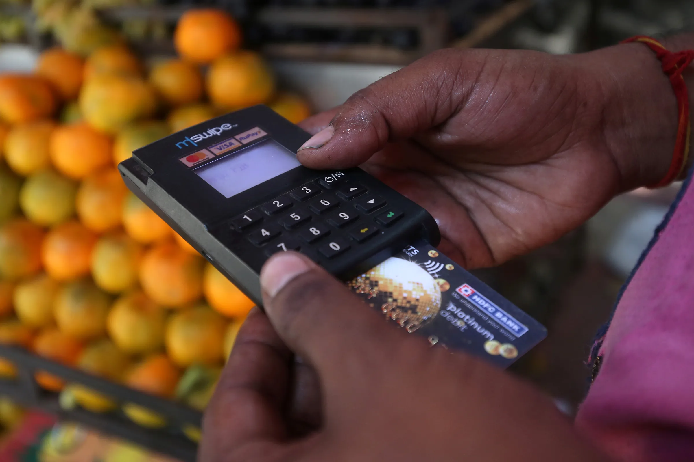 A fruit seller swipes a customer's debit card at a roadside market in Mumbai, India, April 2, 2019. REUTERS/Francis Mascarenhas