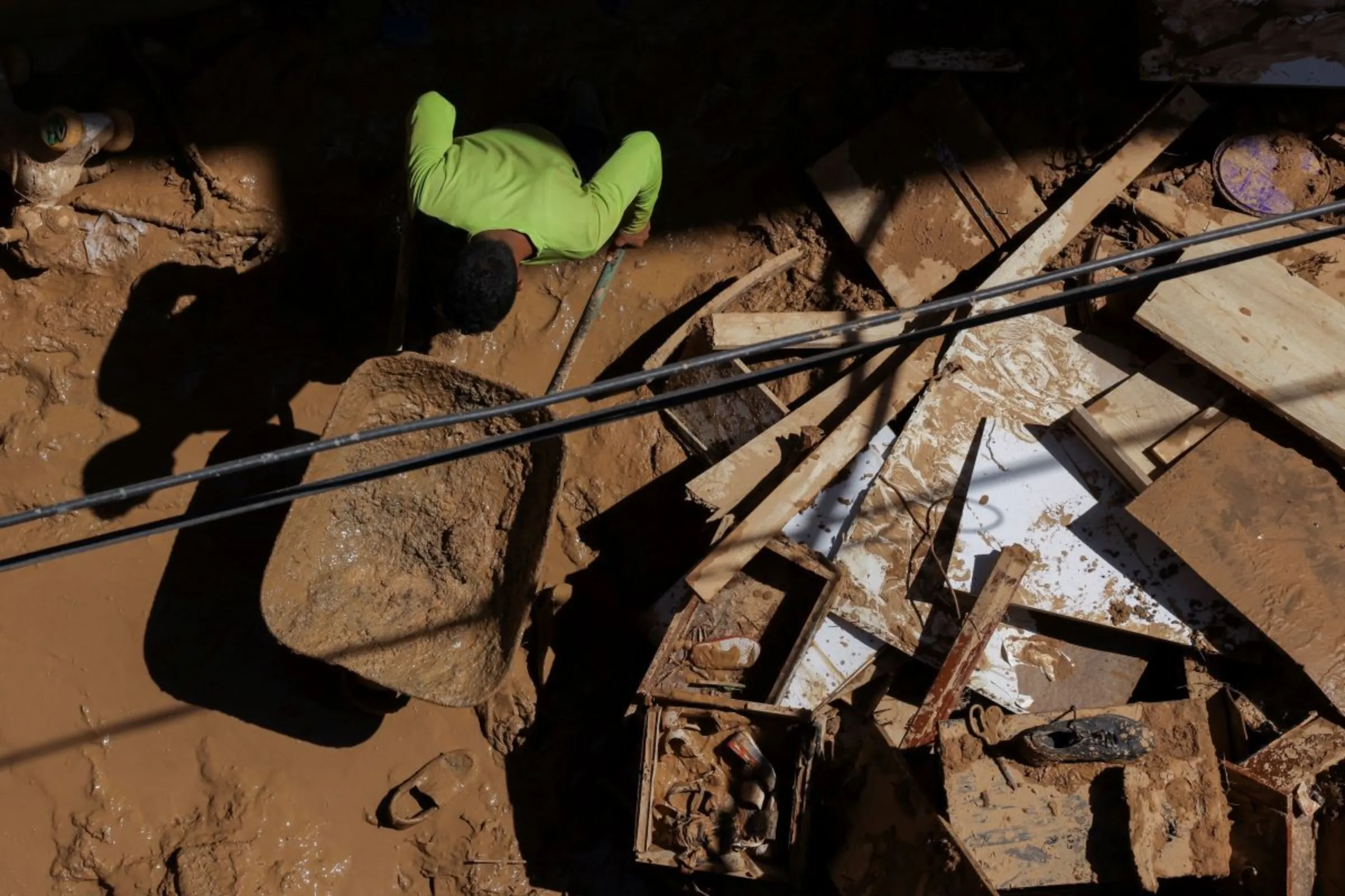 A person moves mud off a house that was impacted by fatal floods in Derna, Libya, September 19, 2023