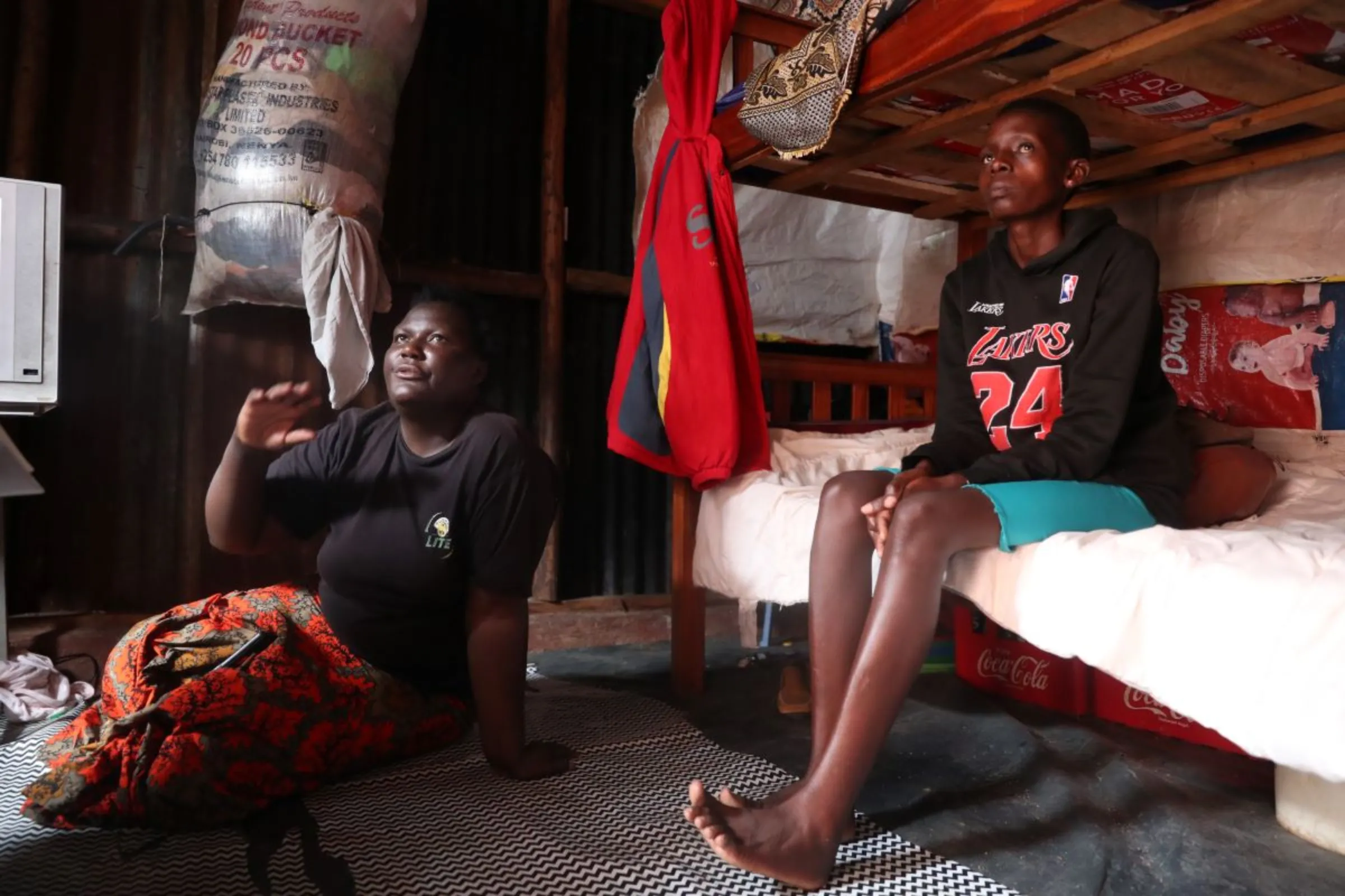 Sheilah Musimbi (R), 16, with her guardian Mercy Indiazi (L) at their home in Kawangware, Nairobi on April 14, 2023