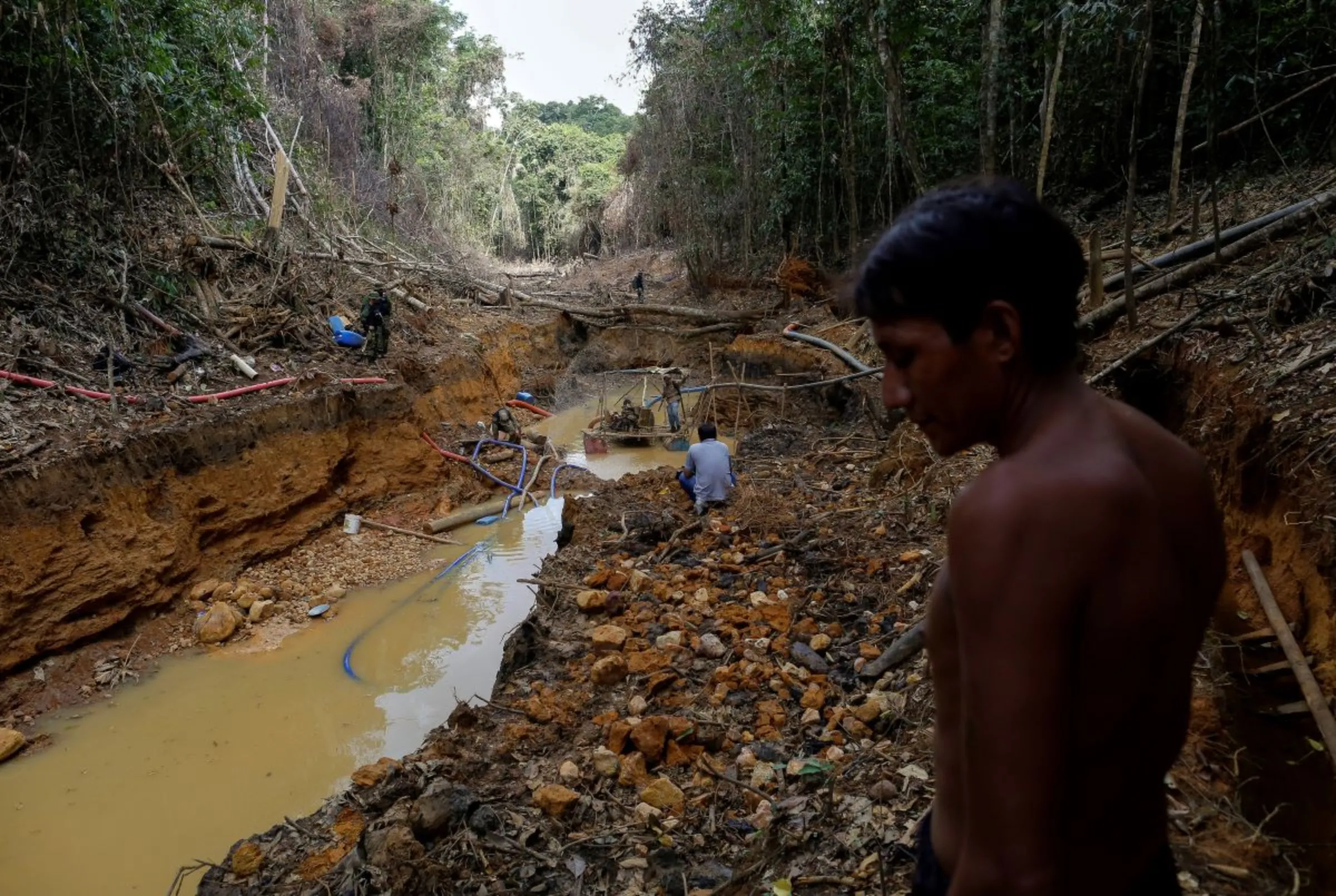 A Yanomami indian follows agents of Brazil's environmental agency in a gold mine during an operation against illegal gold mining on indigenous land, in the heart of the Amazon rainforest, in Roraima state, Brazil April 17, 2016. REUTERS/Bruno Kelly