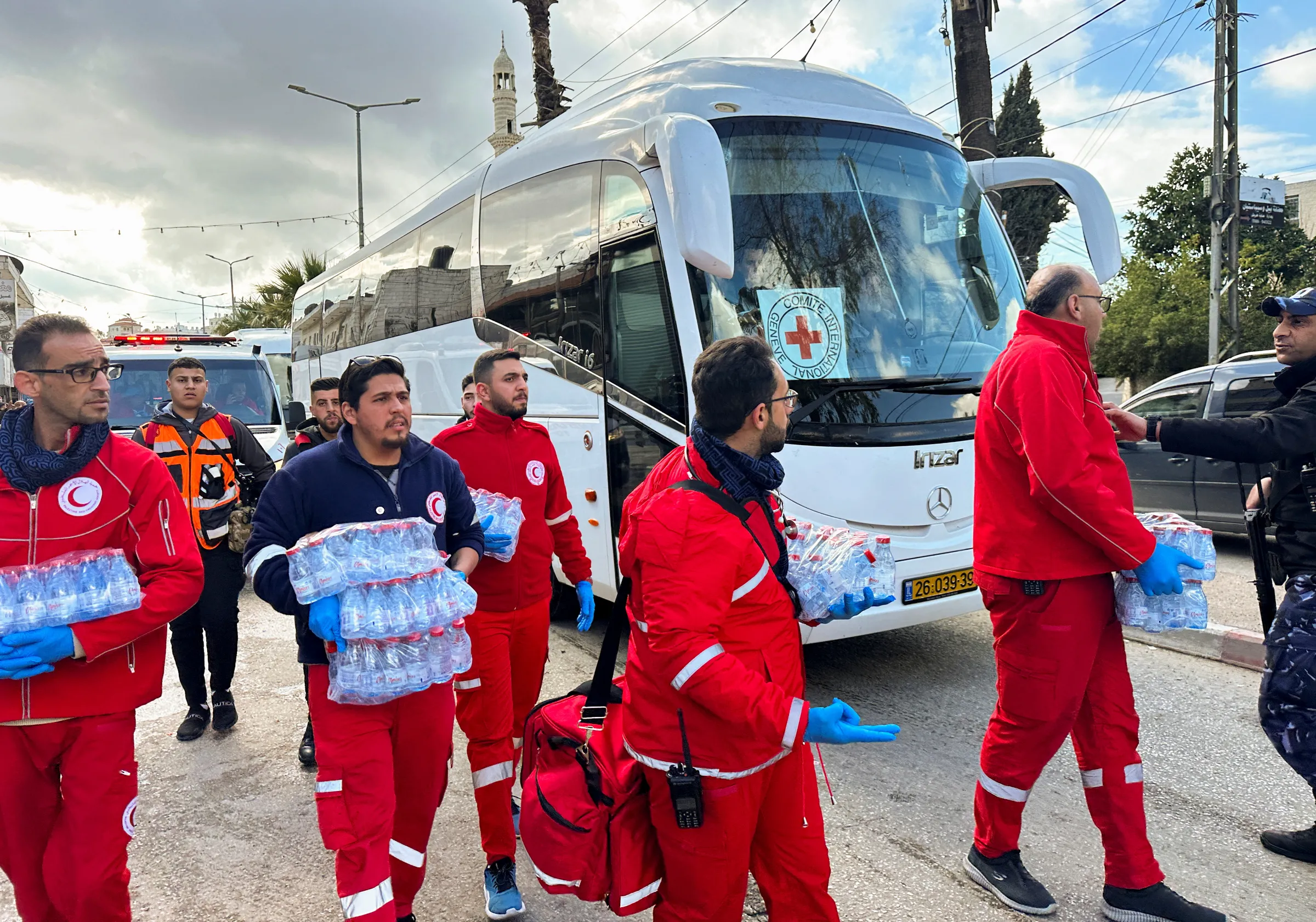 Members of the Palestine Red Crescent Society (PRCS) walk next to a bus carrying freed Palestinian prisoners in Ramallah, in the Israeli-occupied West Bank, January 25, 2025. REUTERS/Ali Sawafta