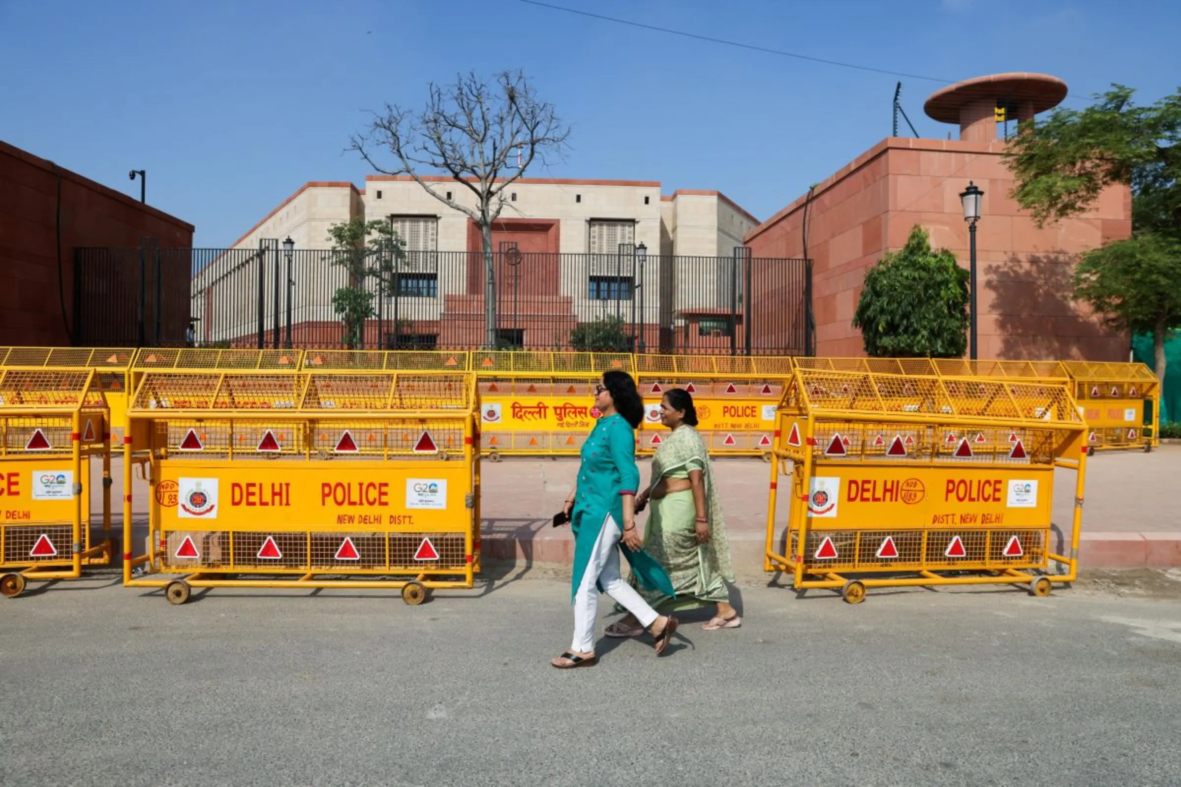 Women walk past India's new parliament in New Delhi, India, September 20, 2023
