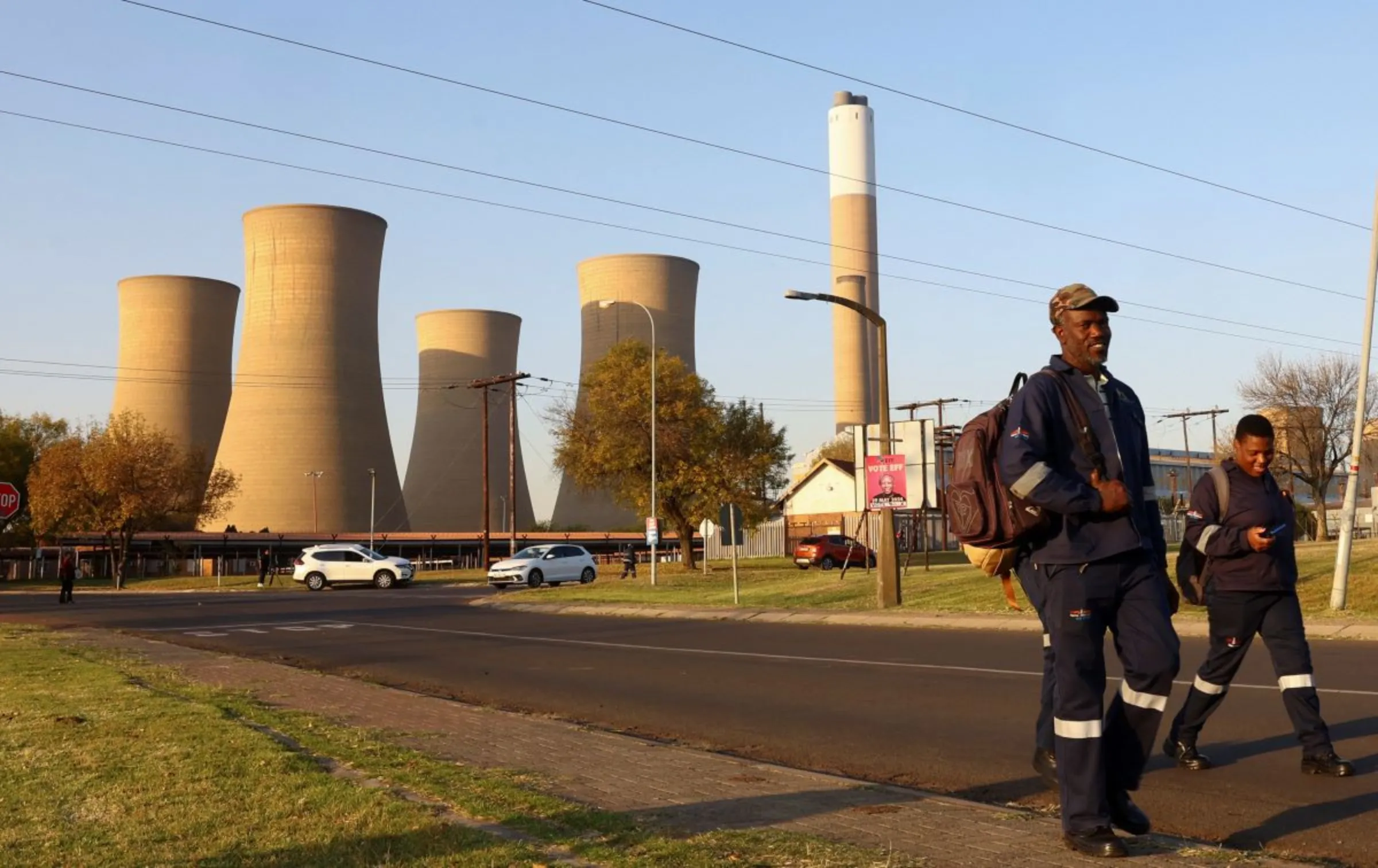 Workers walk past a retired coal-fired Komati Power Station, operated by Eskom near Komati village, in the Mpumalanga province in South Africa, May 9, 2024. REUTERS/Siphiwe Sibeko