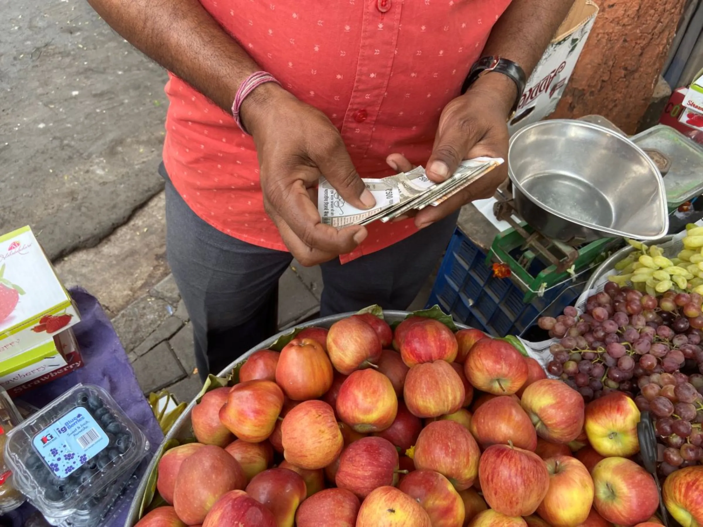 Fruit seller Bachche Lal Sahani, who is among the first users of Reserve Bank of India’s digital currency, counts cash from sales in Mumbai, India, March 2, 2023. Thomson Reuters Foundation/Roli Srivastava