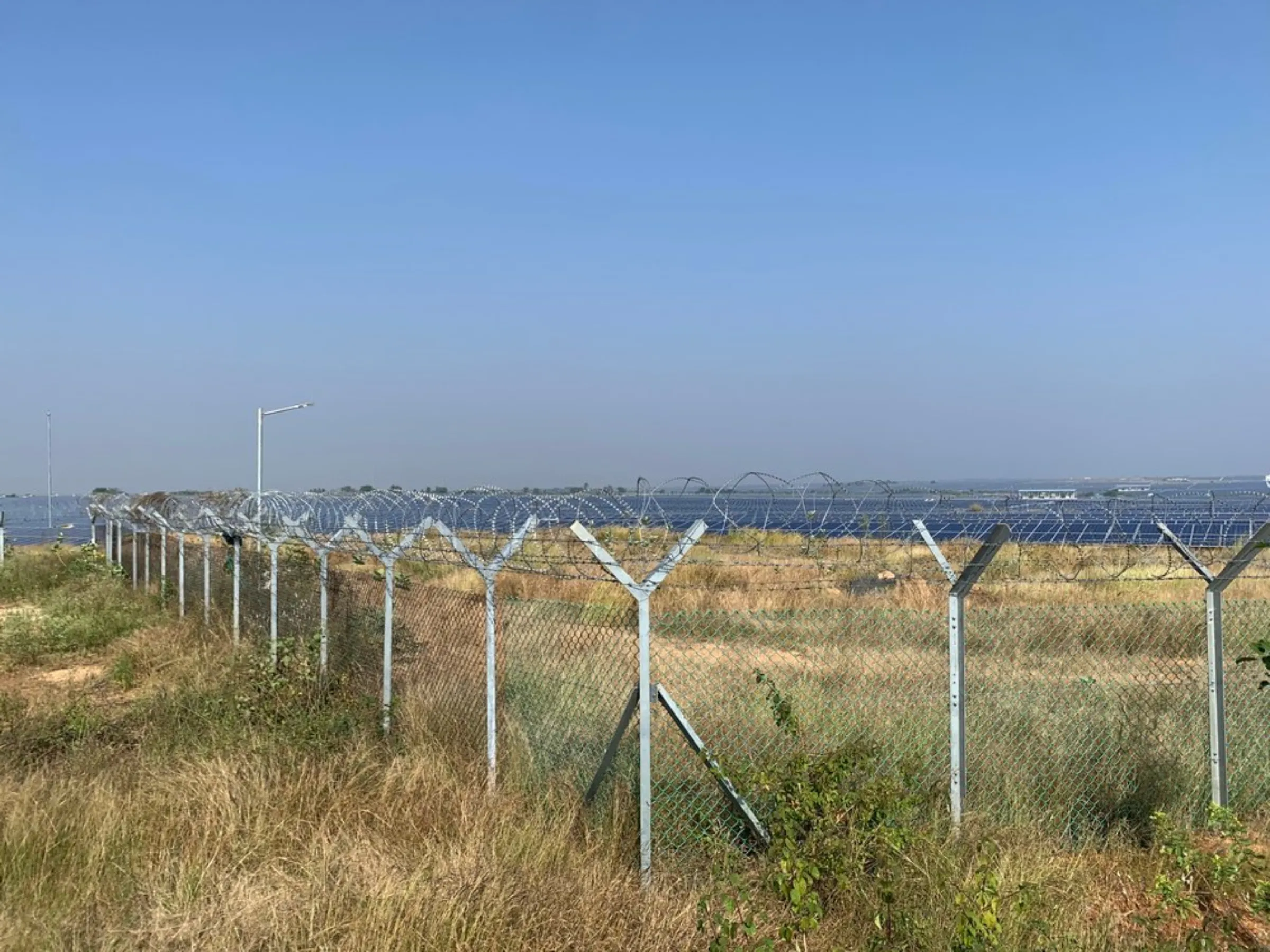Fences separate the Pavagada solar park from the villages nearby in Karnataka, India, December 27, 2021