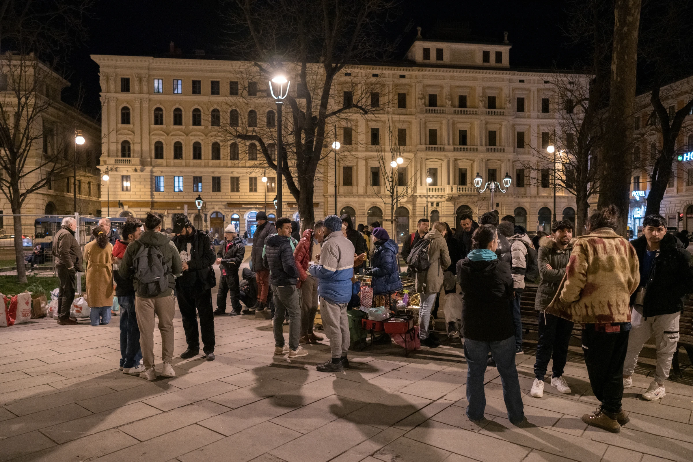 People on the move receive emergency items and information from the International Rescue Committee's outreach team in the Piazza della Liberta, opposite Trieste Centrale railway station, in Trieste, Italy. March 4, 2024. Francesco Pistilli/International Rescue Committee/Handout via Thomson Reuters Foundation