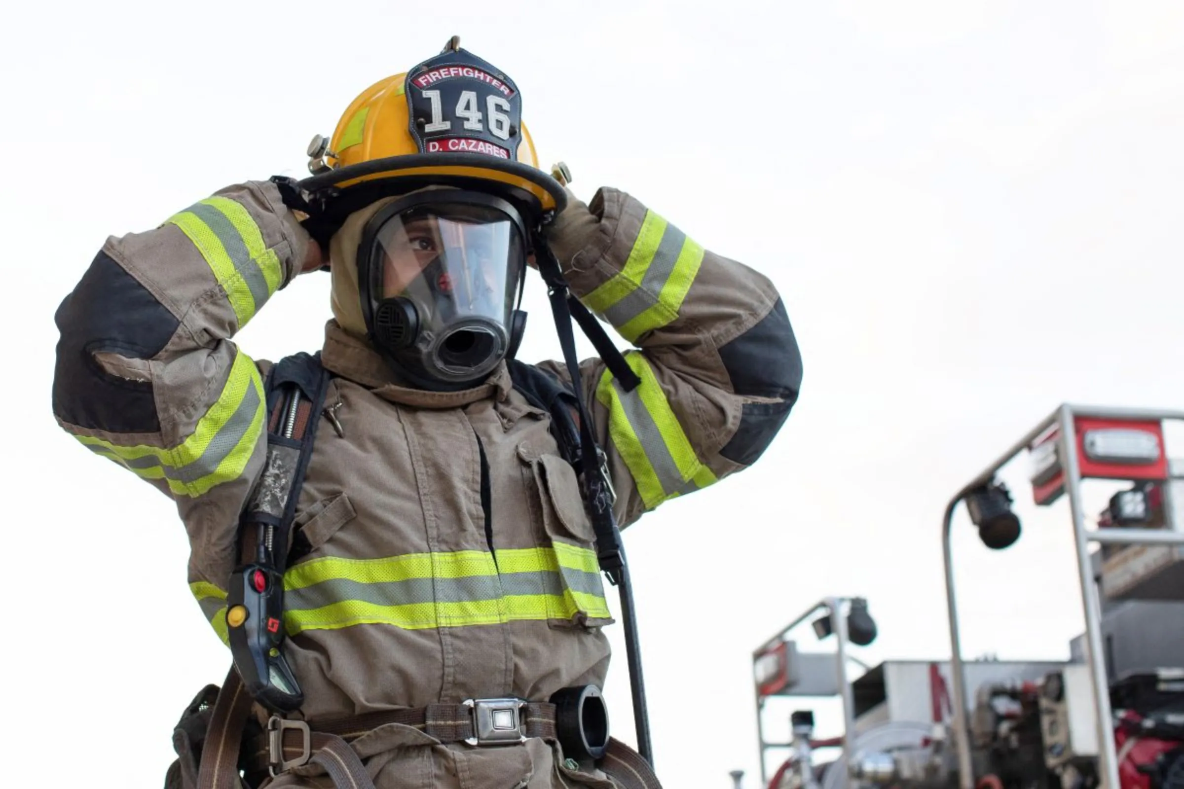 A firefighter puts on his full fire suit and oxygen for a consumption drill training exercise to evaluate performance in an active fire scenario at Station One in Eagle Pass, Texas, U.S., July 08, 2023