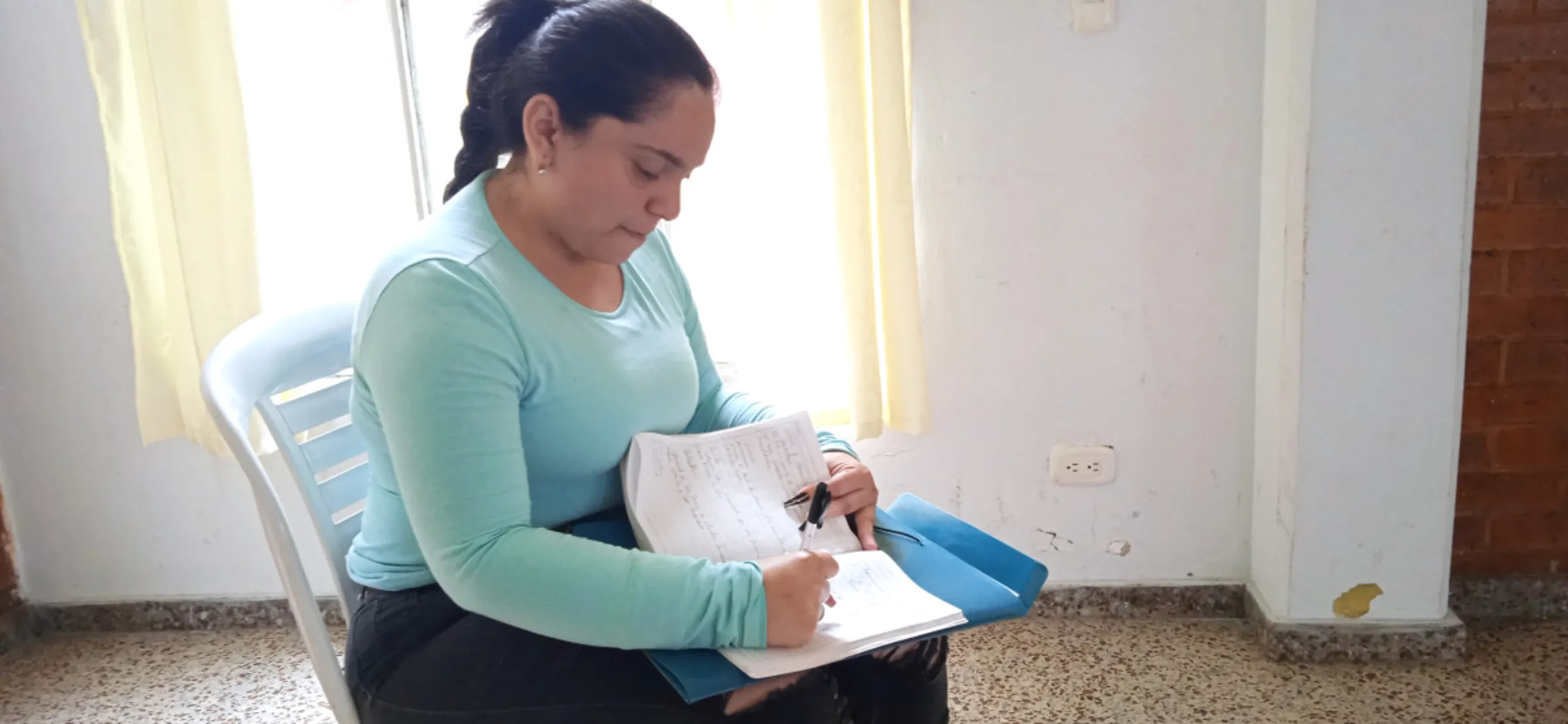 Venezuelan migrant Mairelys Caldera takes notes after attending a financial literacy and entrepreneurship workshop in Bogota, Colombia. June 14, 2023