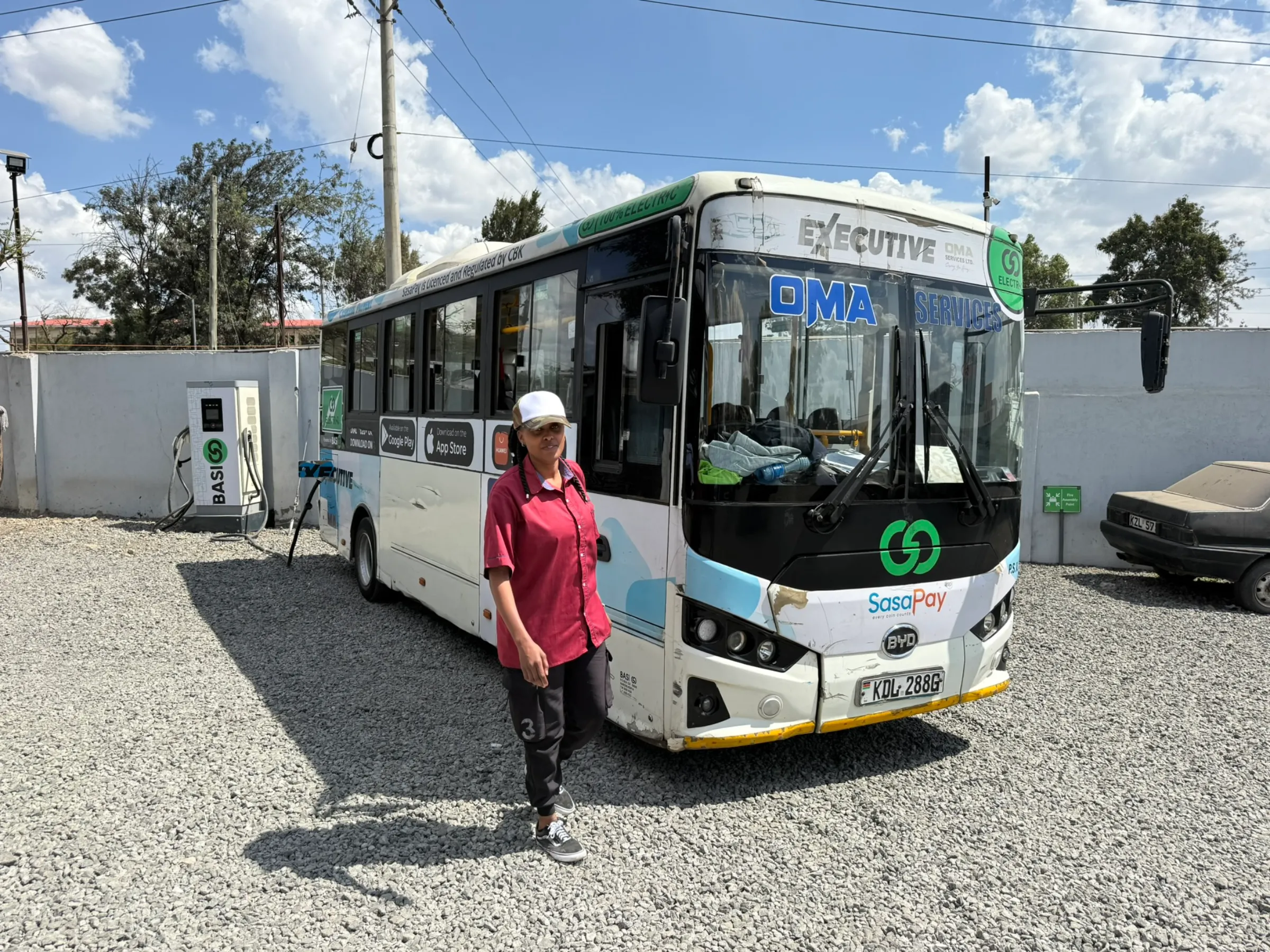 A bus conductor walks past her electric bus at a charging station operated by Kenyan start-up BasiGo in Nairobi, Kenya on  Nov. 5, 2024. Thomson Reuters Foundation/Nita Bhalla