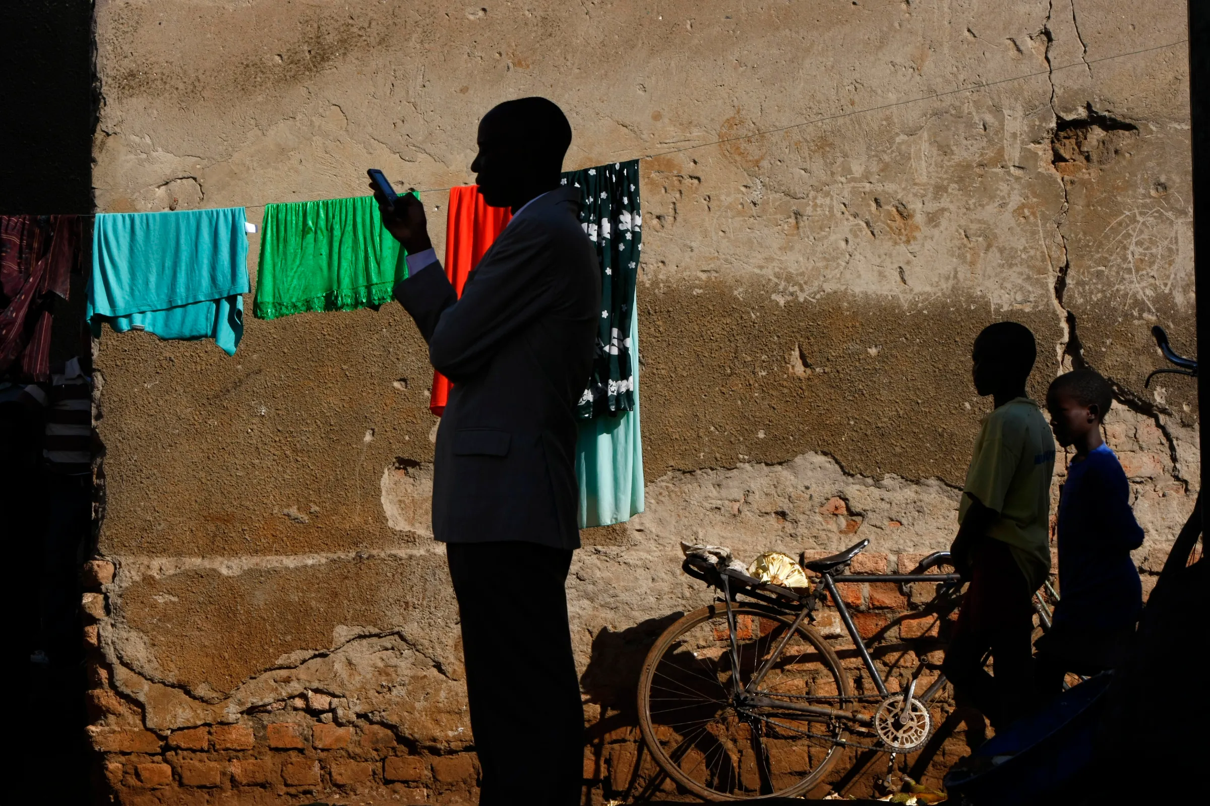 A town official accompanying visiting journalists sends a text message on his phone in the slum of Kachuf in the Masaka district of southern Uganda March 24, 2009. REUTERS/Darrin Zammit Lupi