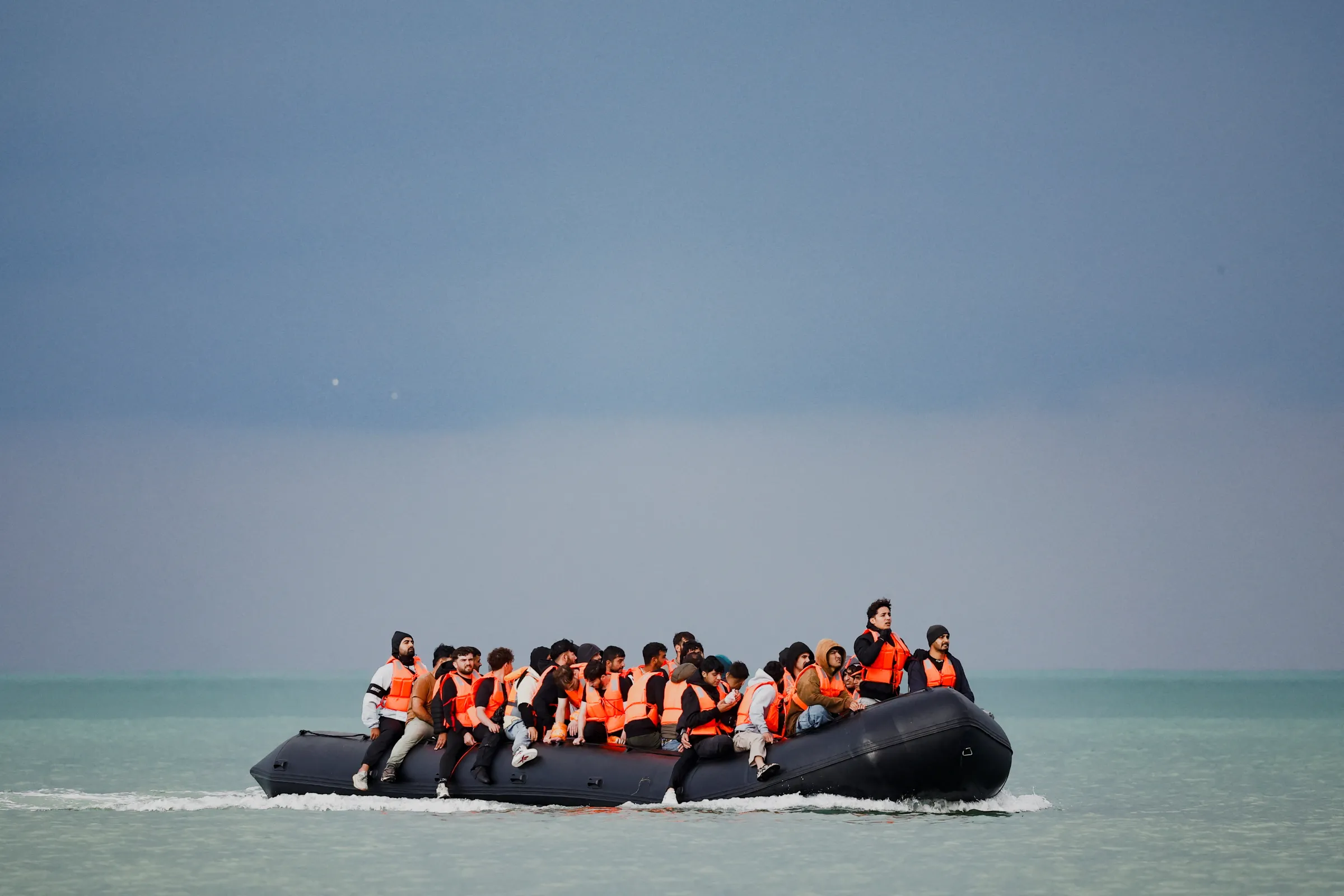 Migrants on an inflatable dinghy attempt to cross the English Channel to reach Britain, on the beach of the Slack dunes in Wimereux, France, September 4, 2024. REUTERS/Benoit Tessier